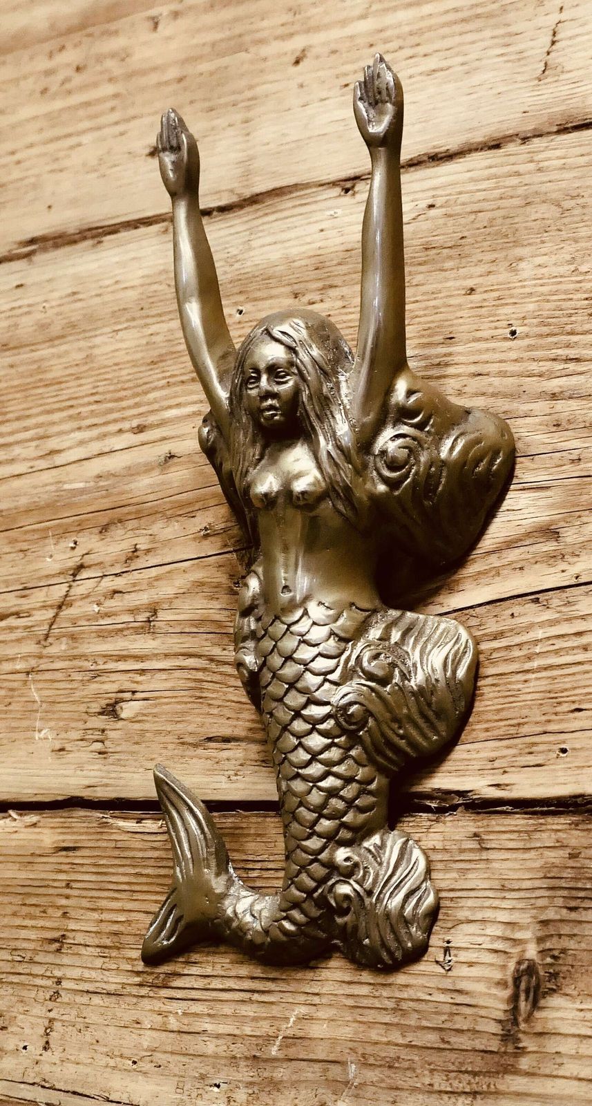 A Brass Door Knocker In The Shape Of A Mermaid photo 330.0