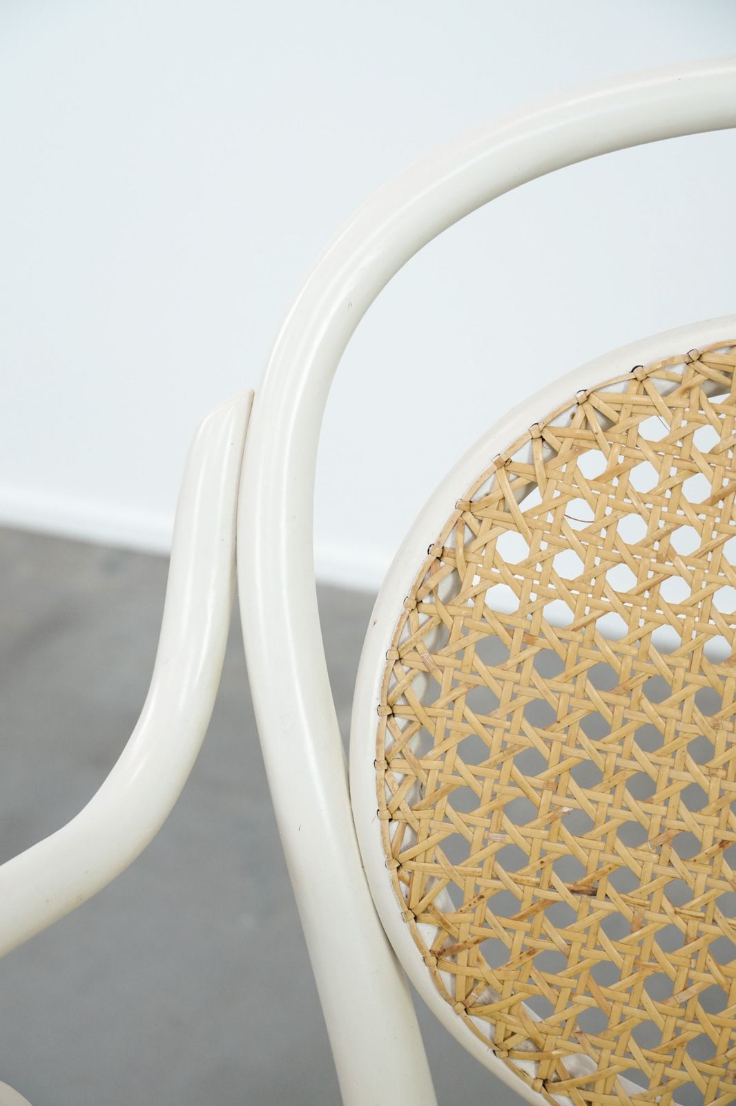 photo furniture Vintage White Bistro Chair With Armrests In Thonet Style With A Graceful Curved Wooden Frame, Webbing Seat And Backrest