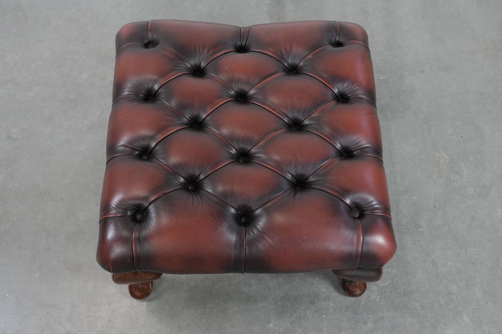 Elegante Donkerbruine Chesterfield Voetenbank Van Koeienhuid photo vinterior