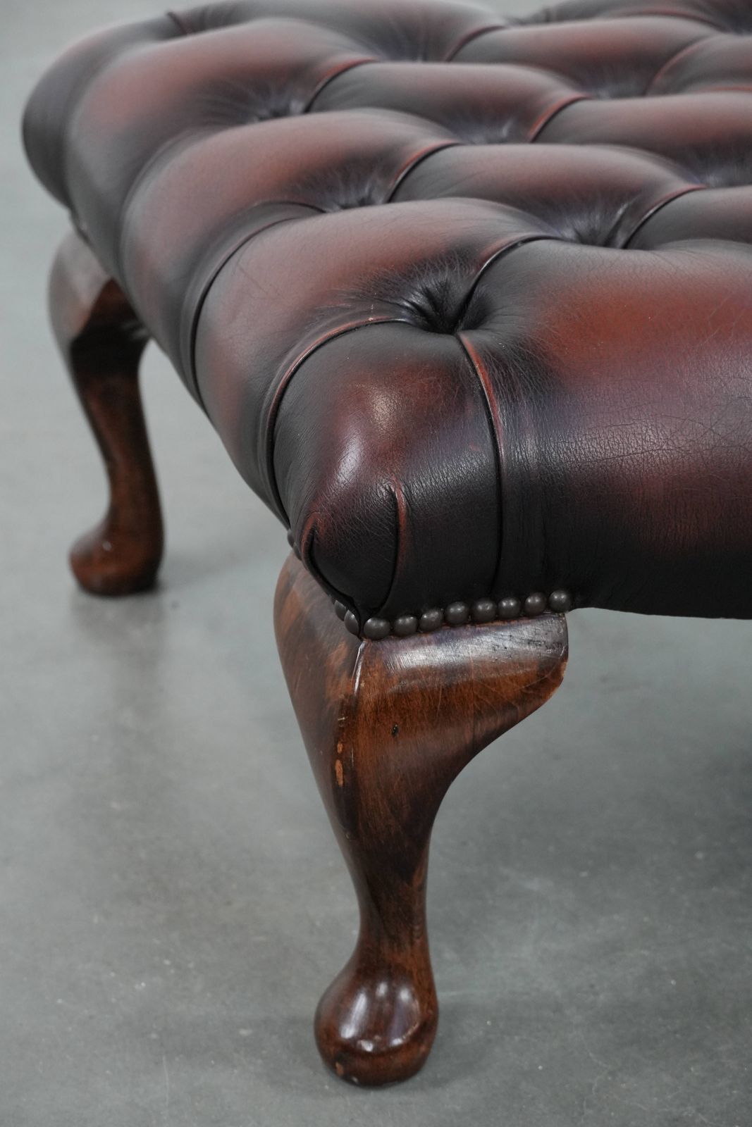 Elegante Donkerbruine Chesterfield Voetenbank Van Koeienhuid photo vintage