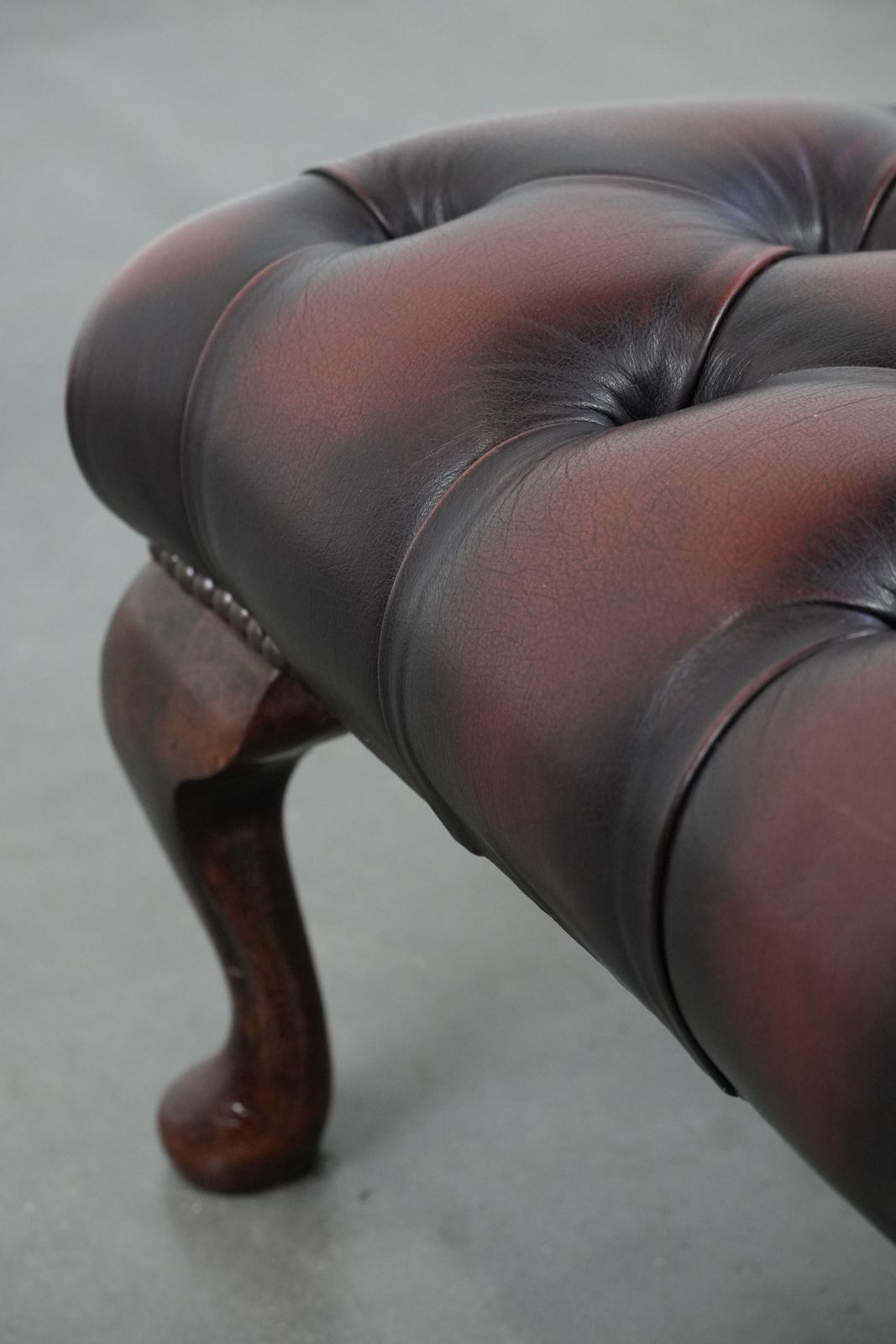 photo furniture Elegant And Graceful Dark Brown Chesterfield Footstool Made Of Cowhide