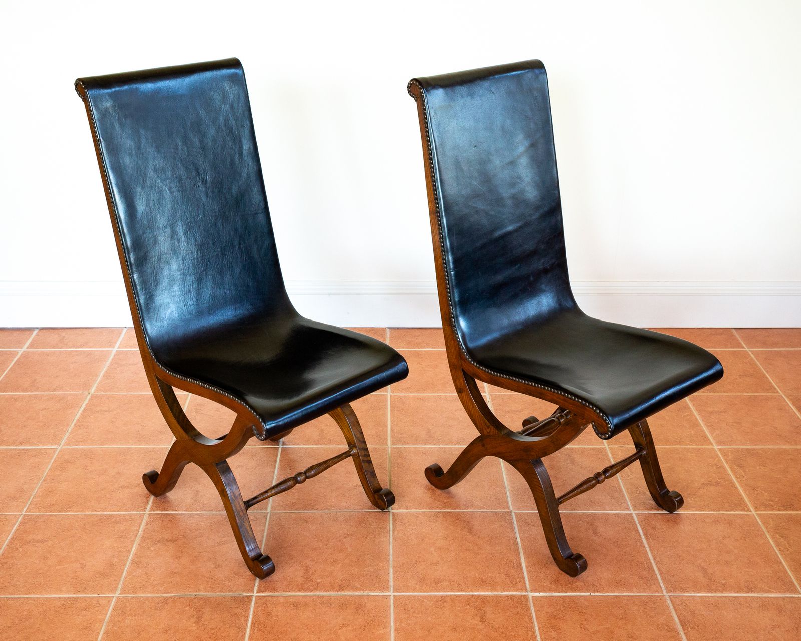 Pair Of Spanish Oak Leather Dining Chairs By Pierre Lottier Valmazan Mid Century Neoclassical Colonial 1960s Black Leather Sling Seat Studded Leather photo vintage