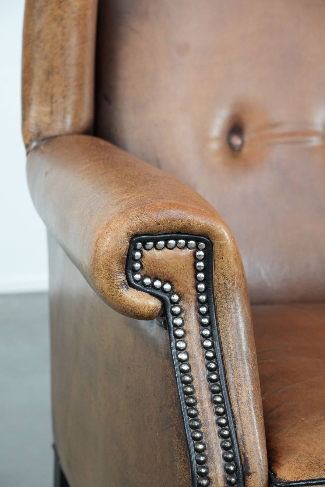 Furniture Large And Comfortable Sheepskin Wing Chair With A Characterful Look With Black Piping And Decorative Studs photo