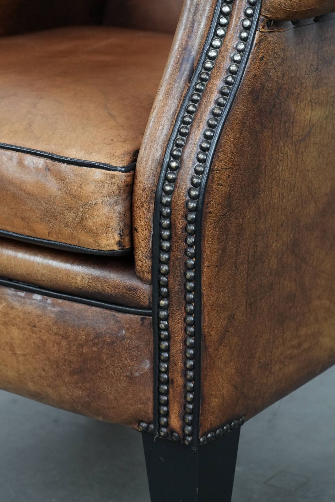 photo vinterior Grote En Comfortabele Schapenvacht Oorfauteuil Met Karakteristiek Uiterlijk, Zwart Bieswerk En Decoratieve Sierspijkers