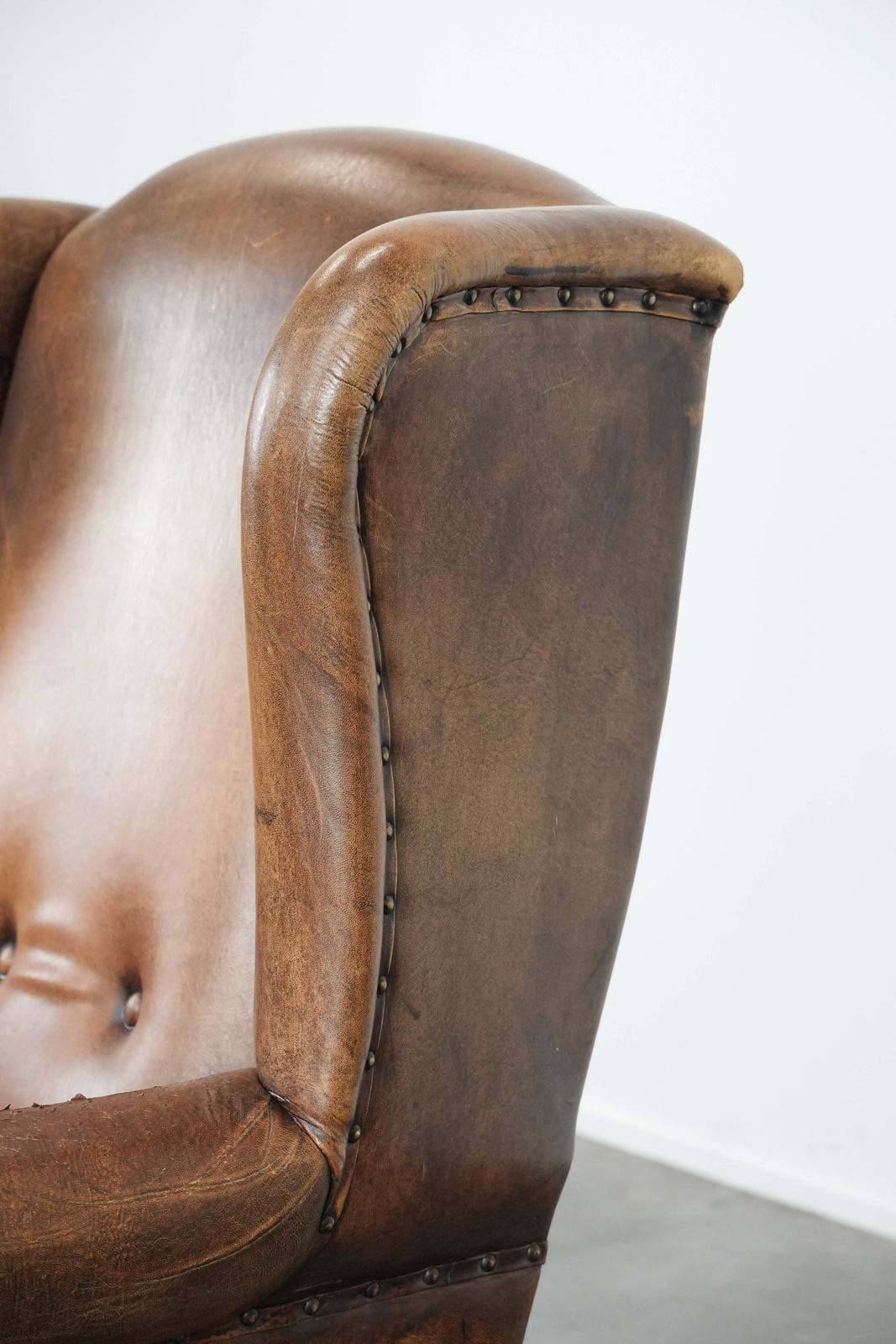 photo buy Large And Comfortable Sheepskin Wing Chair With A Characterful Look With Black Piping And Decorative Studs