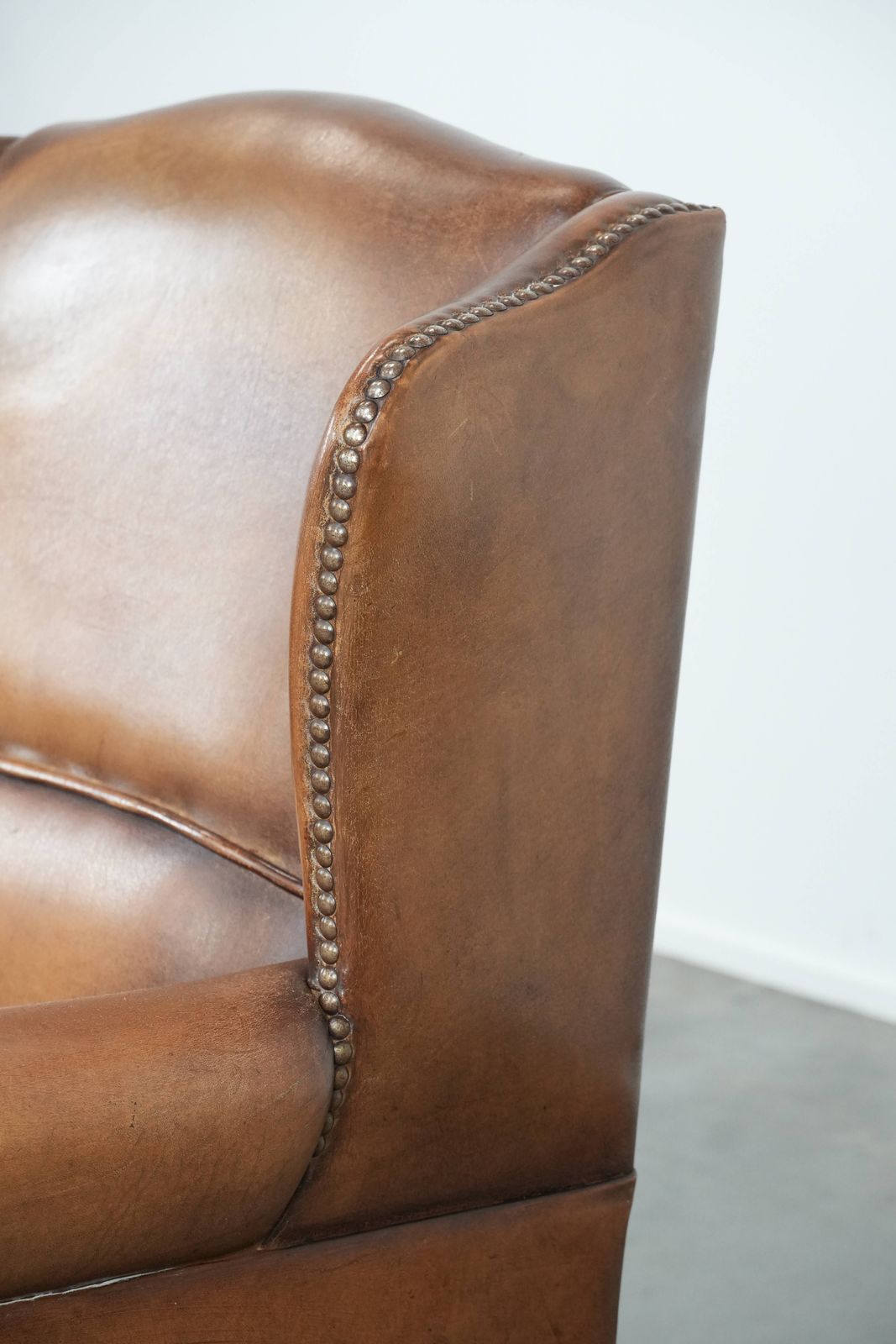 Meubels Charmante Schapenvacht Wingback Fauteuil In Warme Kleuren Met Decoratieve Sierspijkers photo