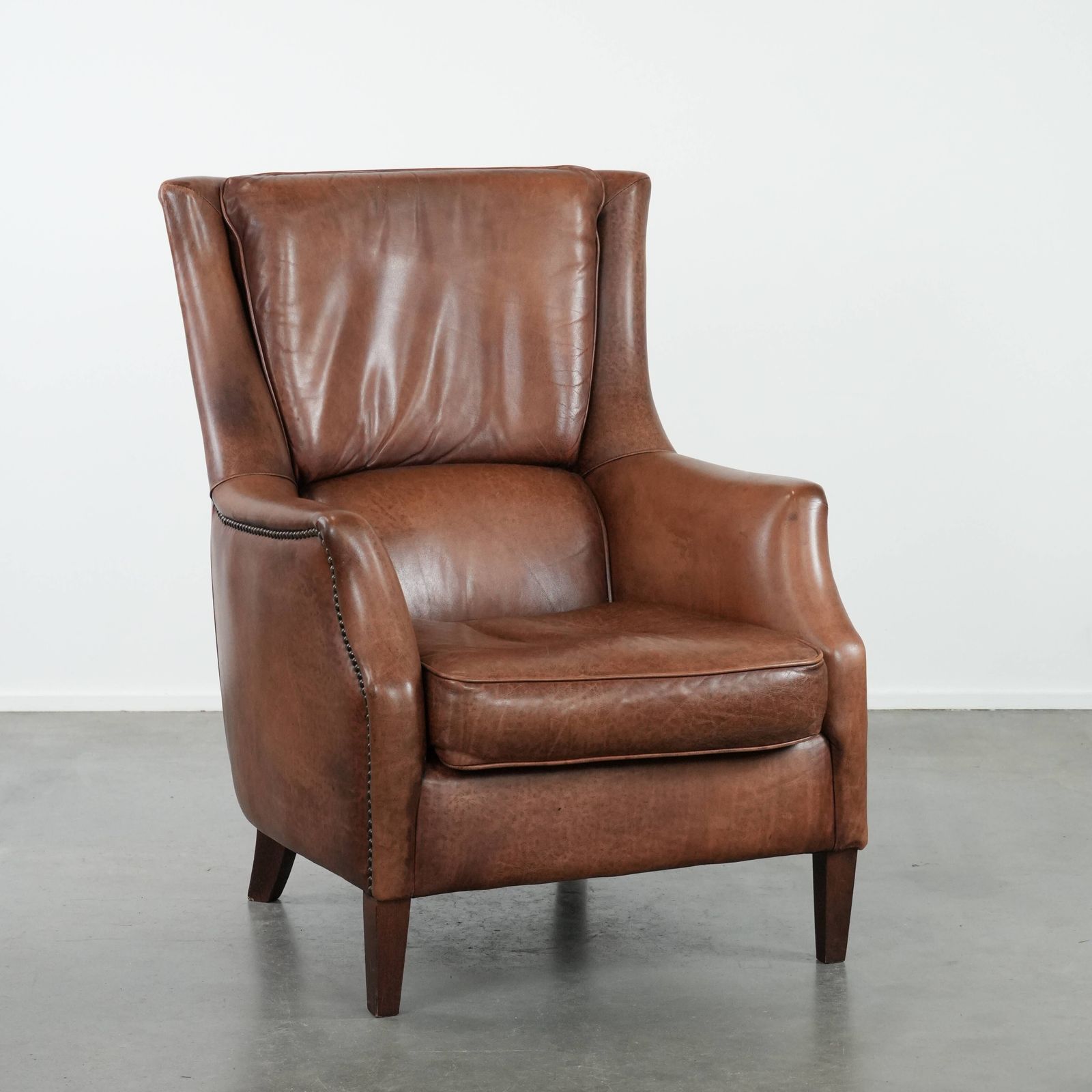 Very Comfortable And Luxurious Cognac Brown Cowhide Armchair With A Decorative Stud Finish