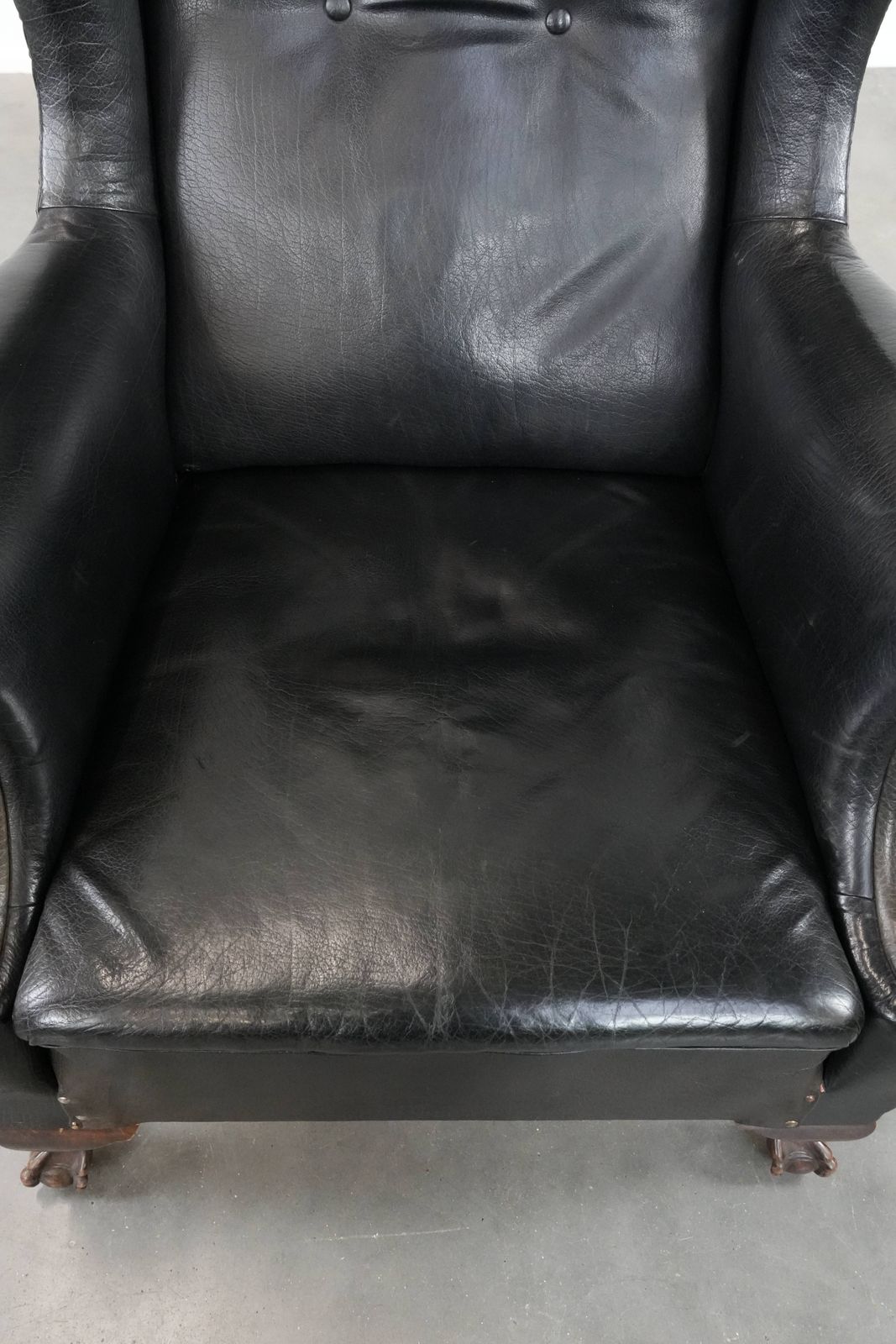 Grote Antieke Engelse Vleugelfauteuil In Zwart Koeienleer, Eind 19e Eeuw, Met Een Weelderige Uitstraling photo vinterior