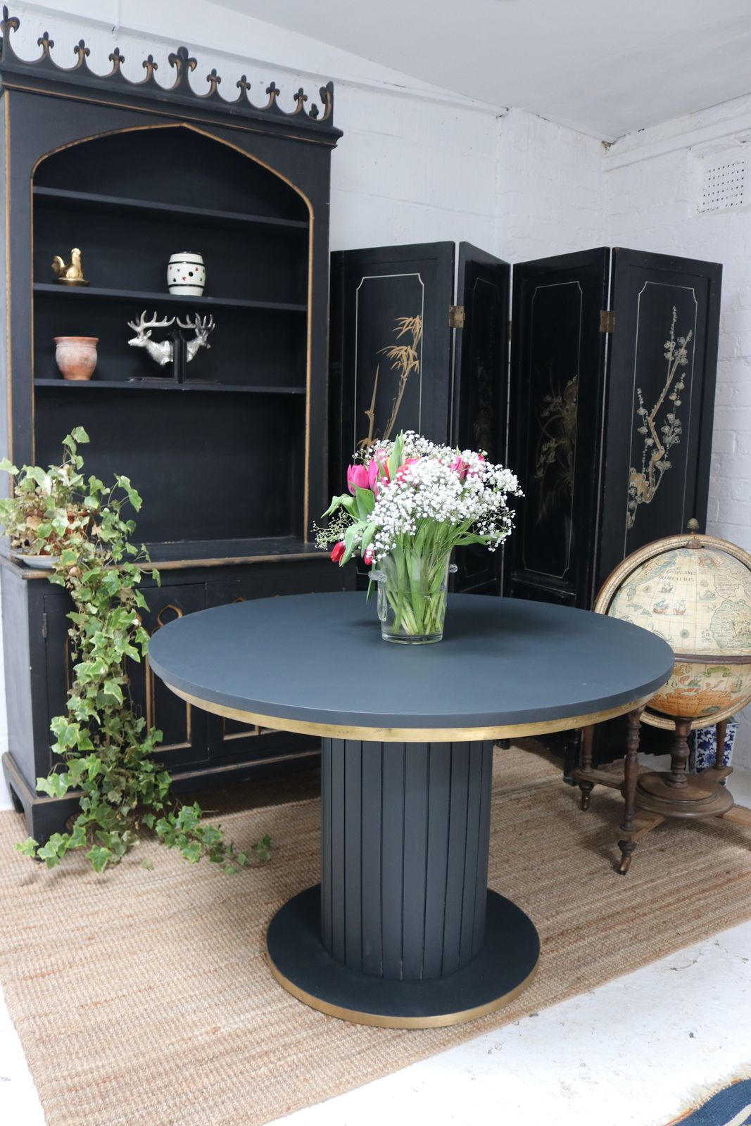 Stunning Black Round Dining Table With Brass Metal Edge Slatted Wood Column Base photo furniture