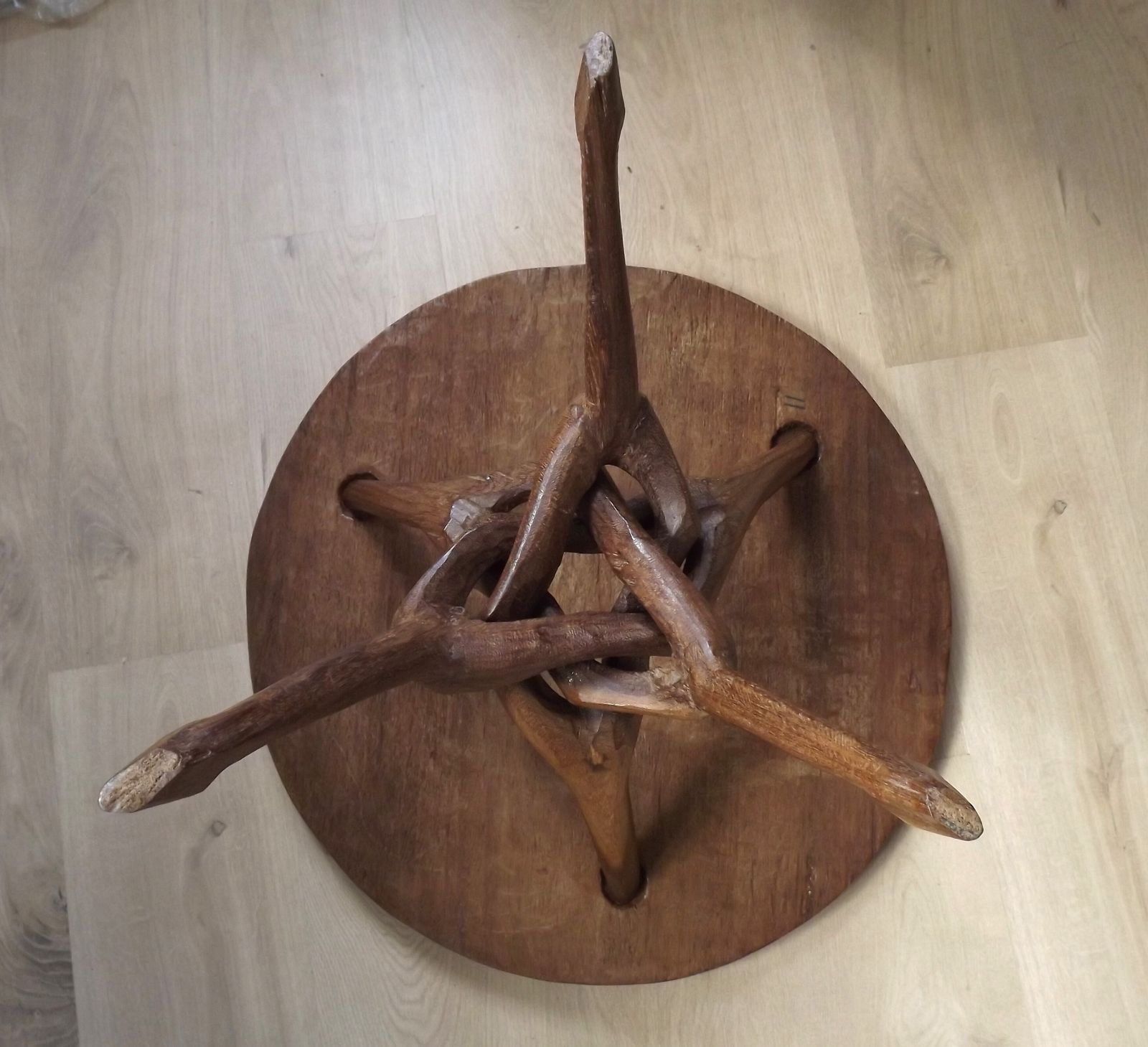 Table d'appoint en bois dur africain sculpté, plateau géométrique et pieds entrelacés photo vinterior