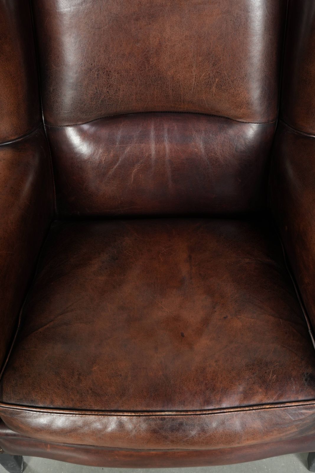 Beautiful Large And Comfortable Sheepskin Wing Armchair With Lovely Deep And Warm Colors And A Finish With Decorative Nails. photo vinterior