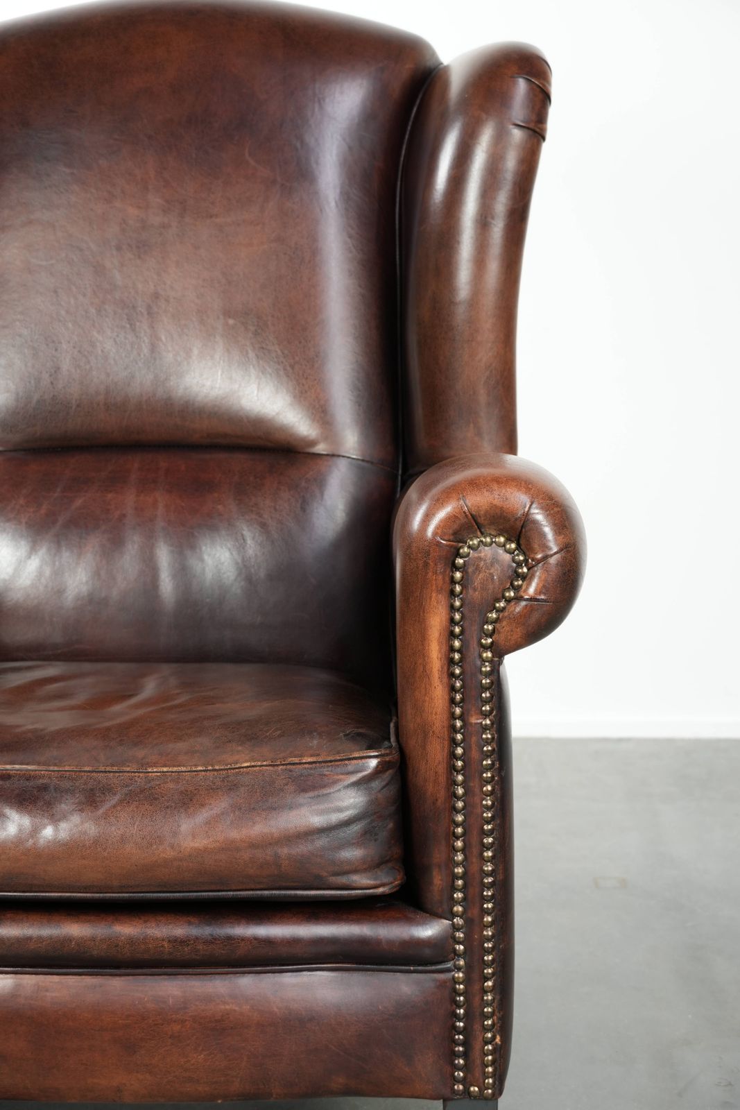 photo furniture Beautiful Large And Comfortable Sheepskin Wing Armchair With Lovely Deep And Warm Colors And A Finish With Decorative Nails.