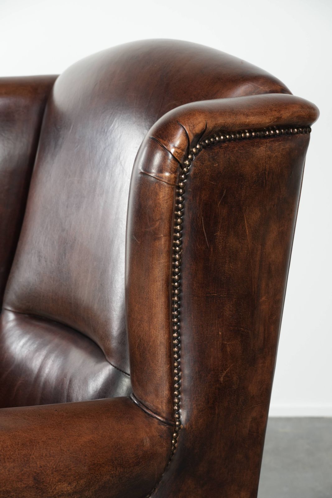 Furniture Beautiful Large And Comfortable Sheepskin Wing Armchair With Lovely Deep And Warm Colors And A Finish With Decorative Nails. photo