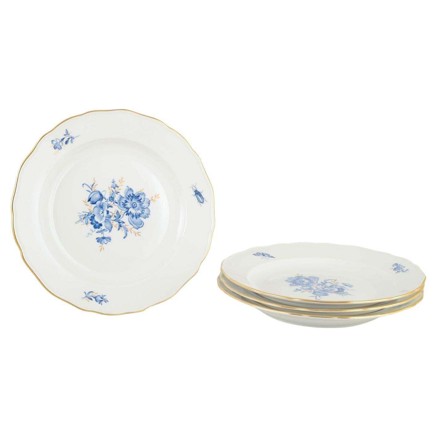 Meissen. 4 assiettes de table en porcelaine à motifs floraux bleus et liseré doré.