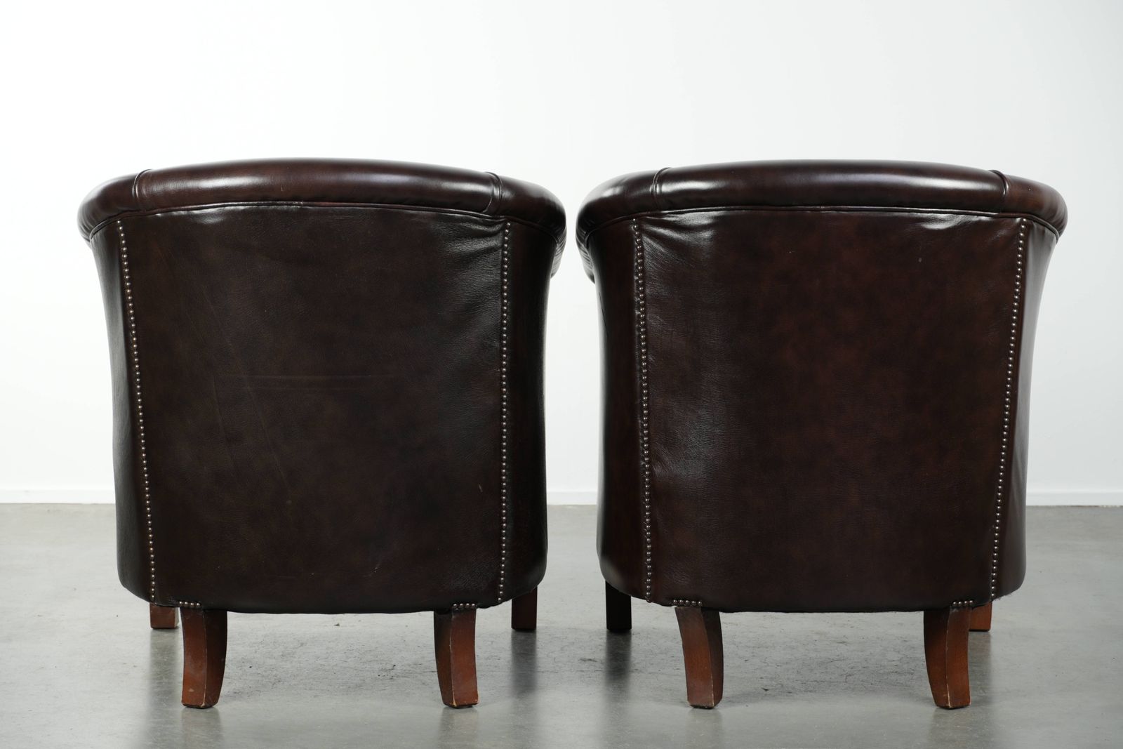 Set Van Twee Donkere Koeienhuid Club Fauteuils In Goede Staat Met Een Tijdloos Engelse Stijl Design photo for sale