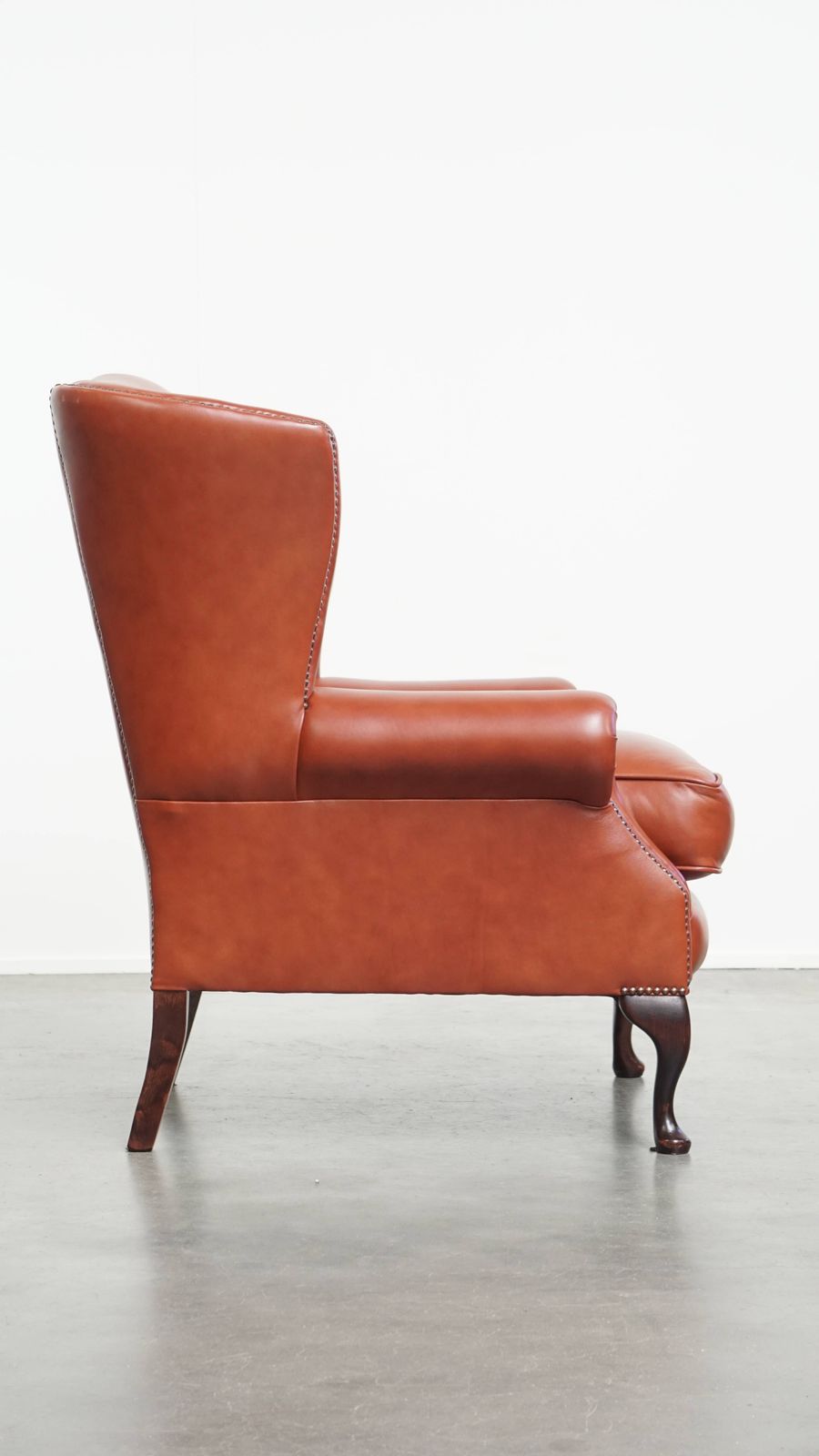 Elegante En Comfortabele Chesterfield Vleugelfauteuil In Glad Engelse Koeienhuid Met Sierlijke Poten photo for sale