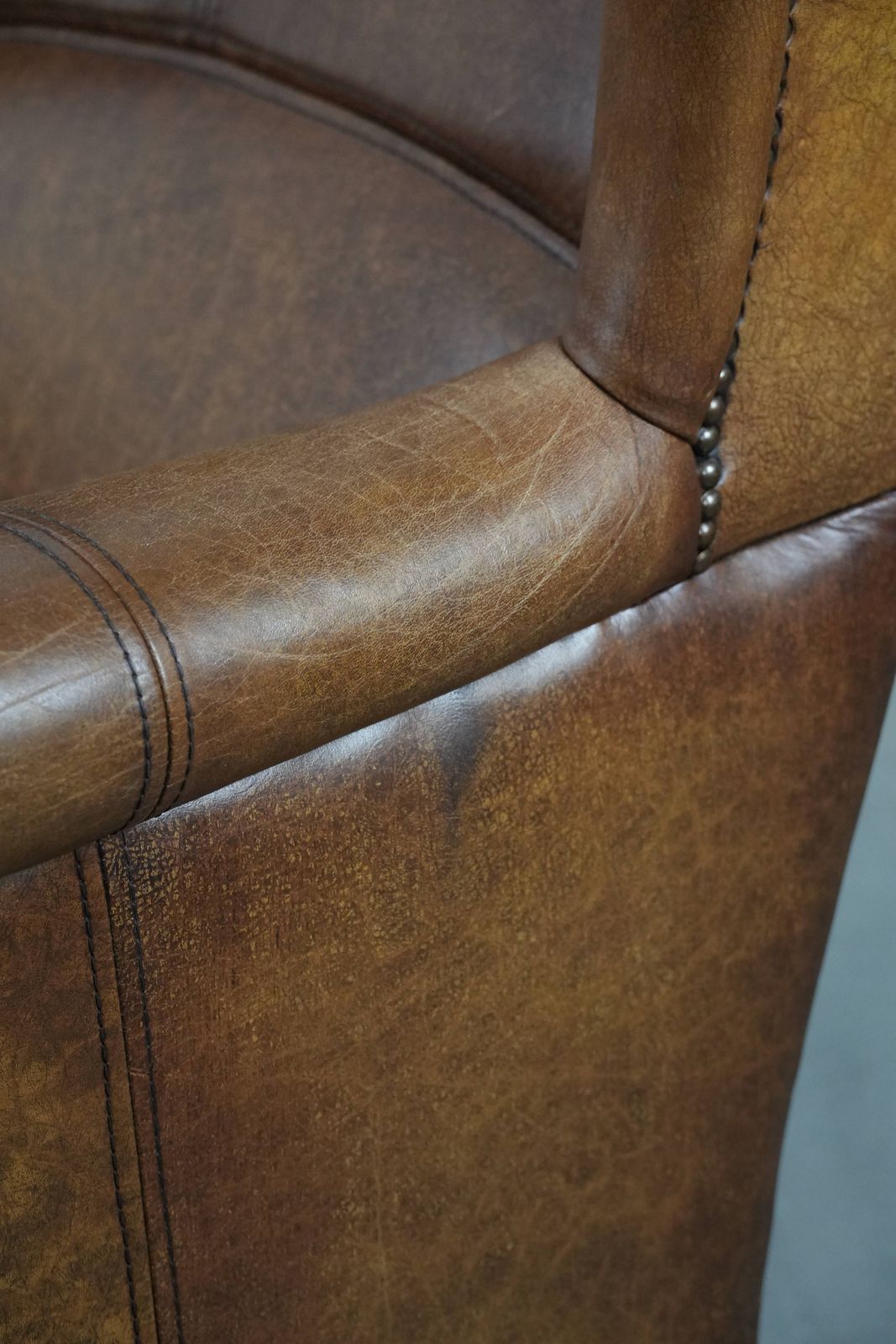 Furniture Timeless Cognac Colored Wing Armchair In English Style Made Of Cowhide Leather, Finished With Decorative Studs And Beautiful Details. photo