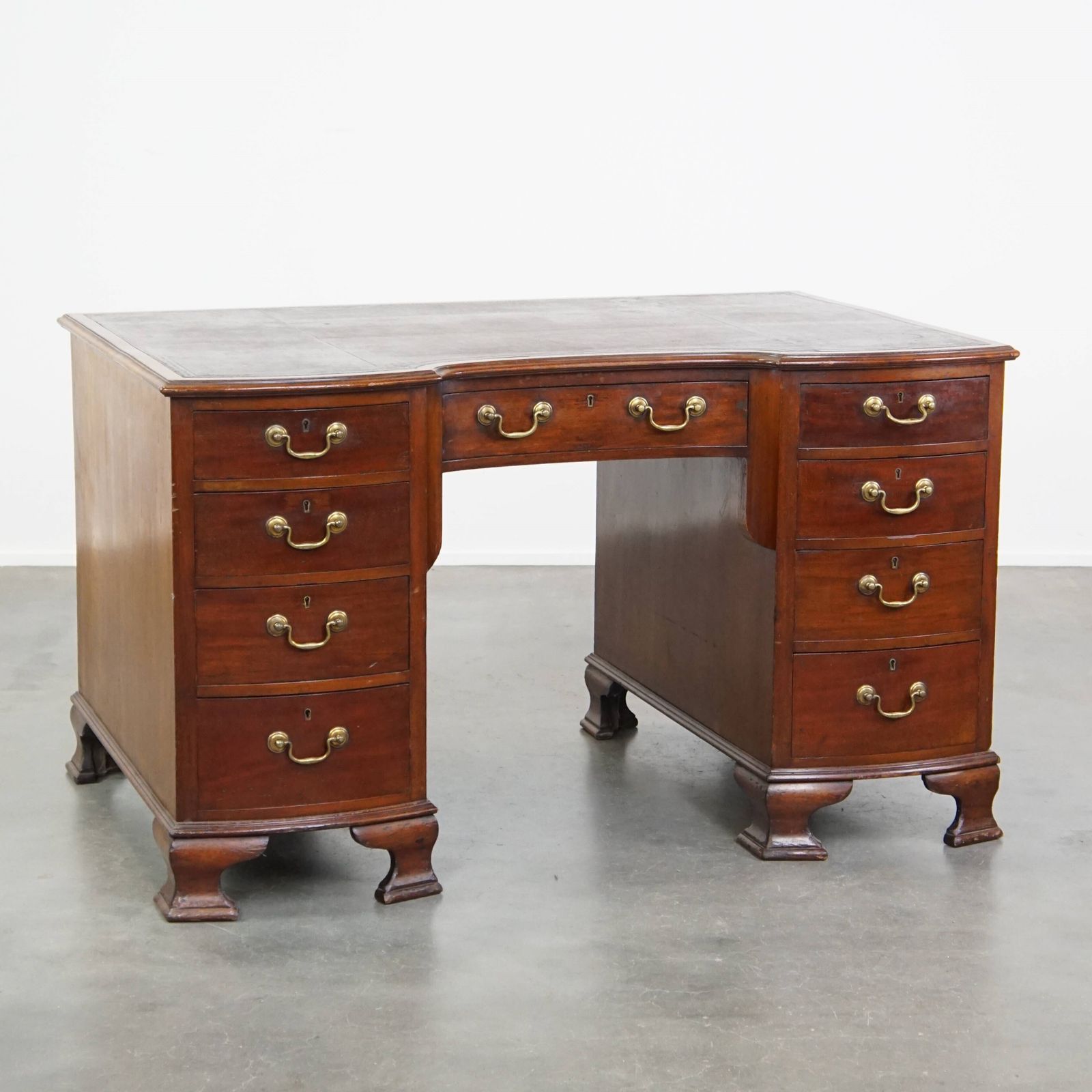 Antiek Engels Houten Bureau Uit De Eind 19e Eeuw Met Lederen Blad En Gebogen Front.