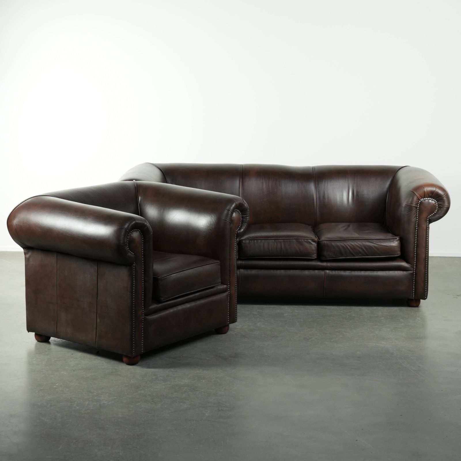 Luxe Bruine Runderlederen Set Bestaande Uit Een Gladde Chesterfield Bank En Fauteuil Met Een Tijdloze Engelse Uitstraling