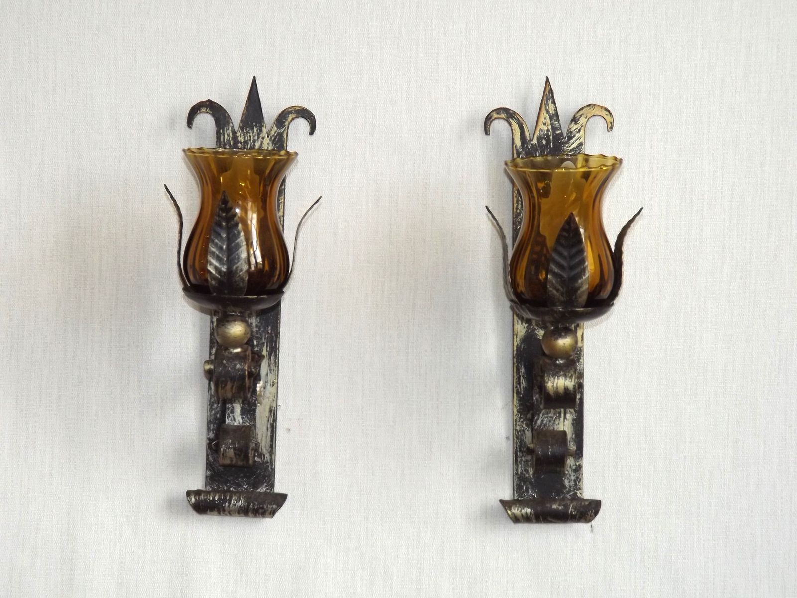 Paar handgesmede smeedijzeren wandlampen in middeleeuwse stijl met amberkleurige glazen kappen photo furniture