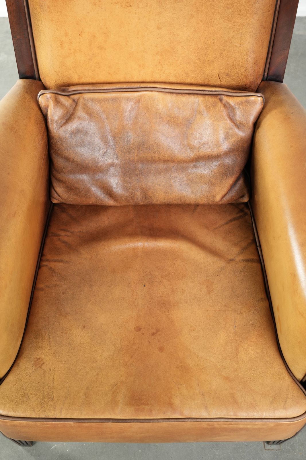 Comfortable Cognac Colored Art Deco Design Armchair Made Of Sheepskin Combined With Wood, With A High Back. photo vinterior