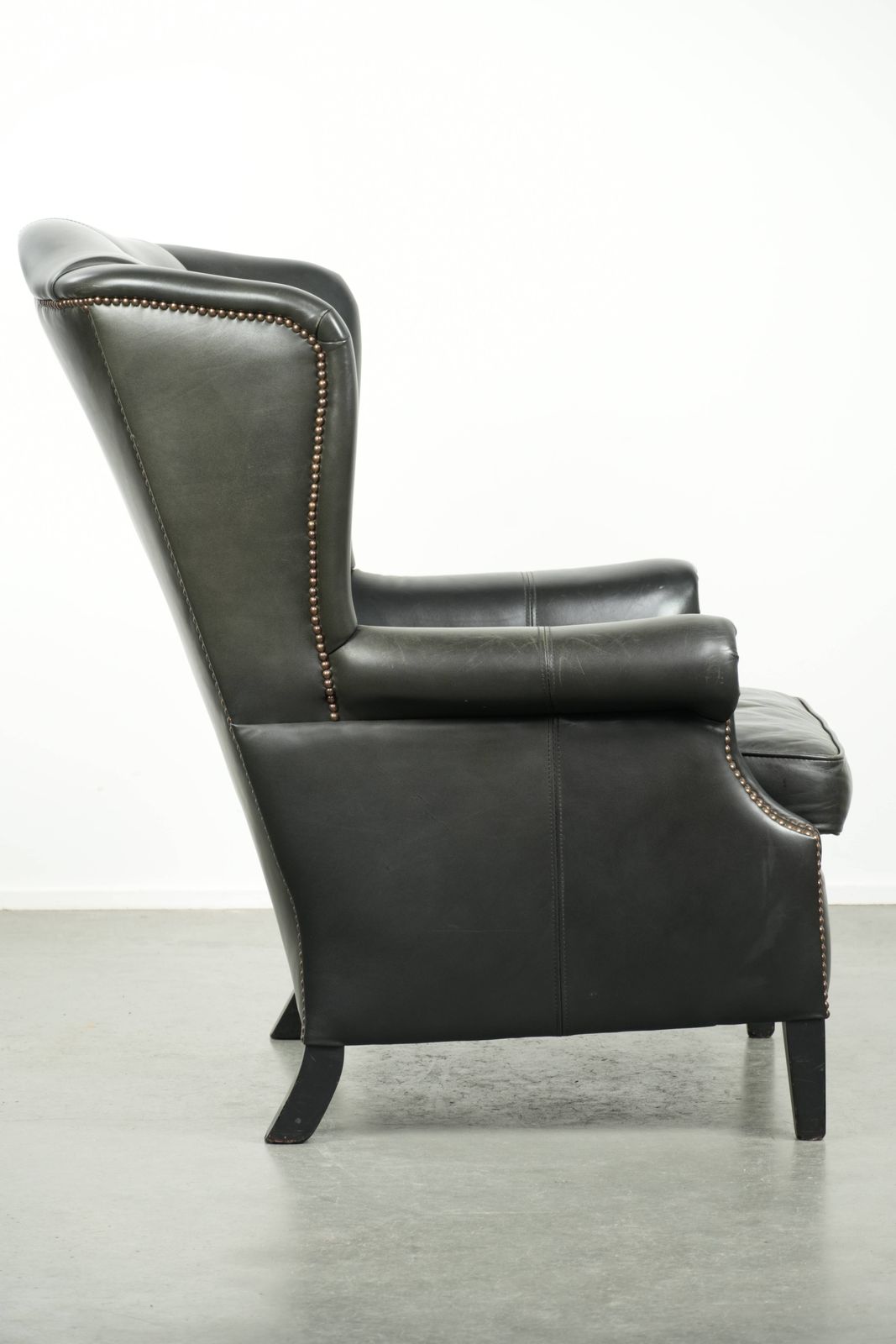 Zwarte Koeienhuid Fauteuil Met Vleugelleuningen In Klassieke Engelse Stijl, Afgewerkt Met Decoratieve Siernagels. photo for sale