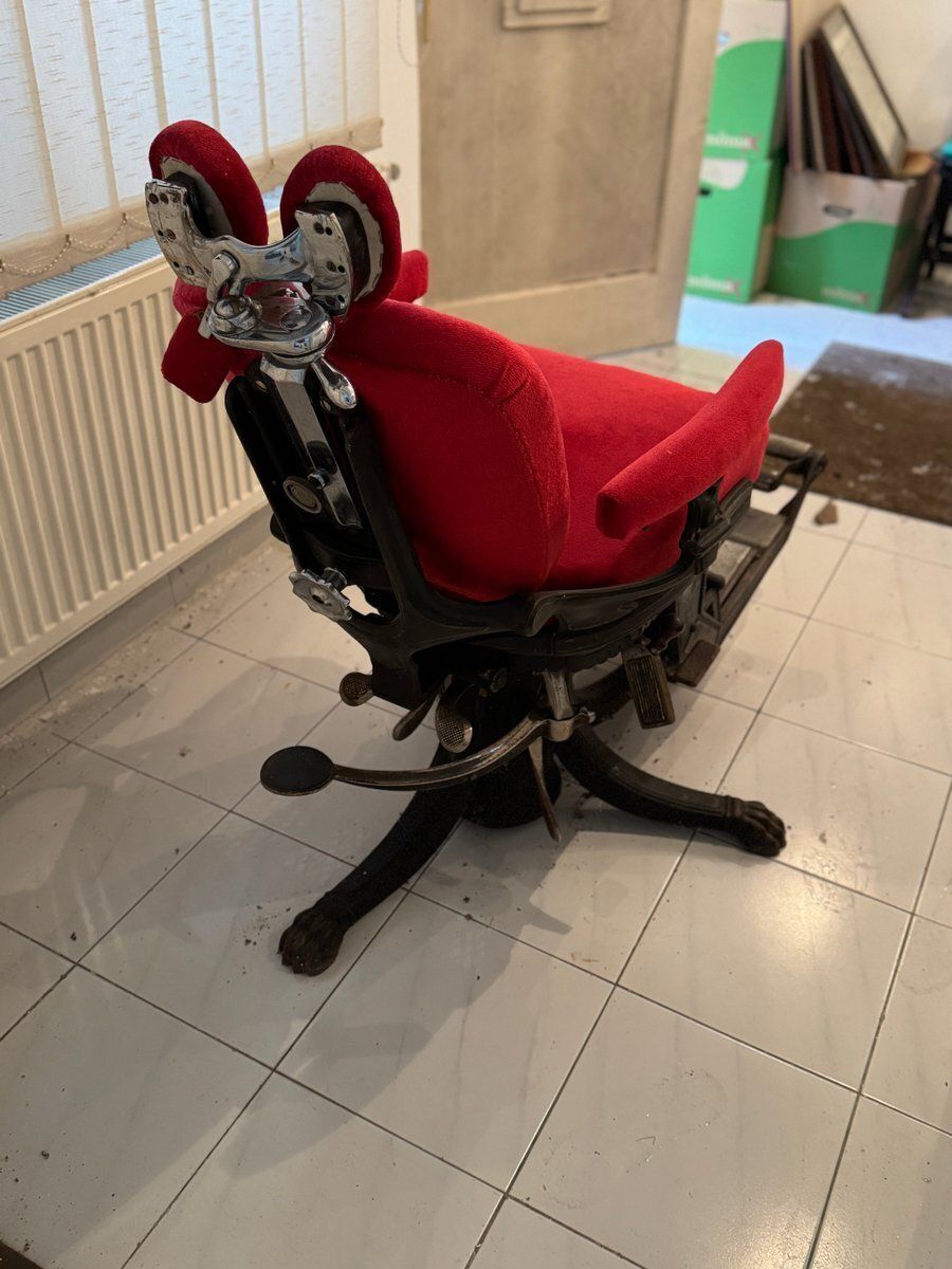 Kappersstoel met rode bekleding en verstelbare voetensteun photo for sale