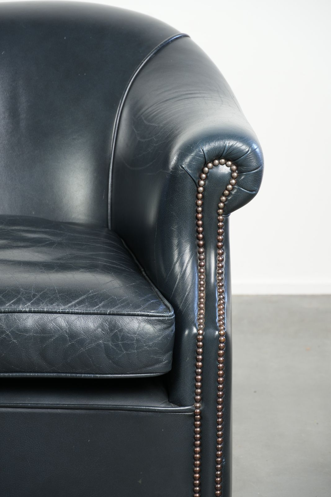photo furniture Mooie en comfortabele donkerblauwe lederen club fauteuil met een uniek en tijdloos design
