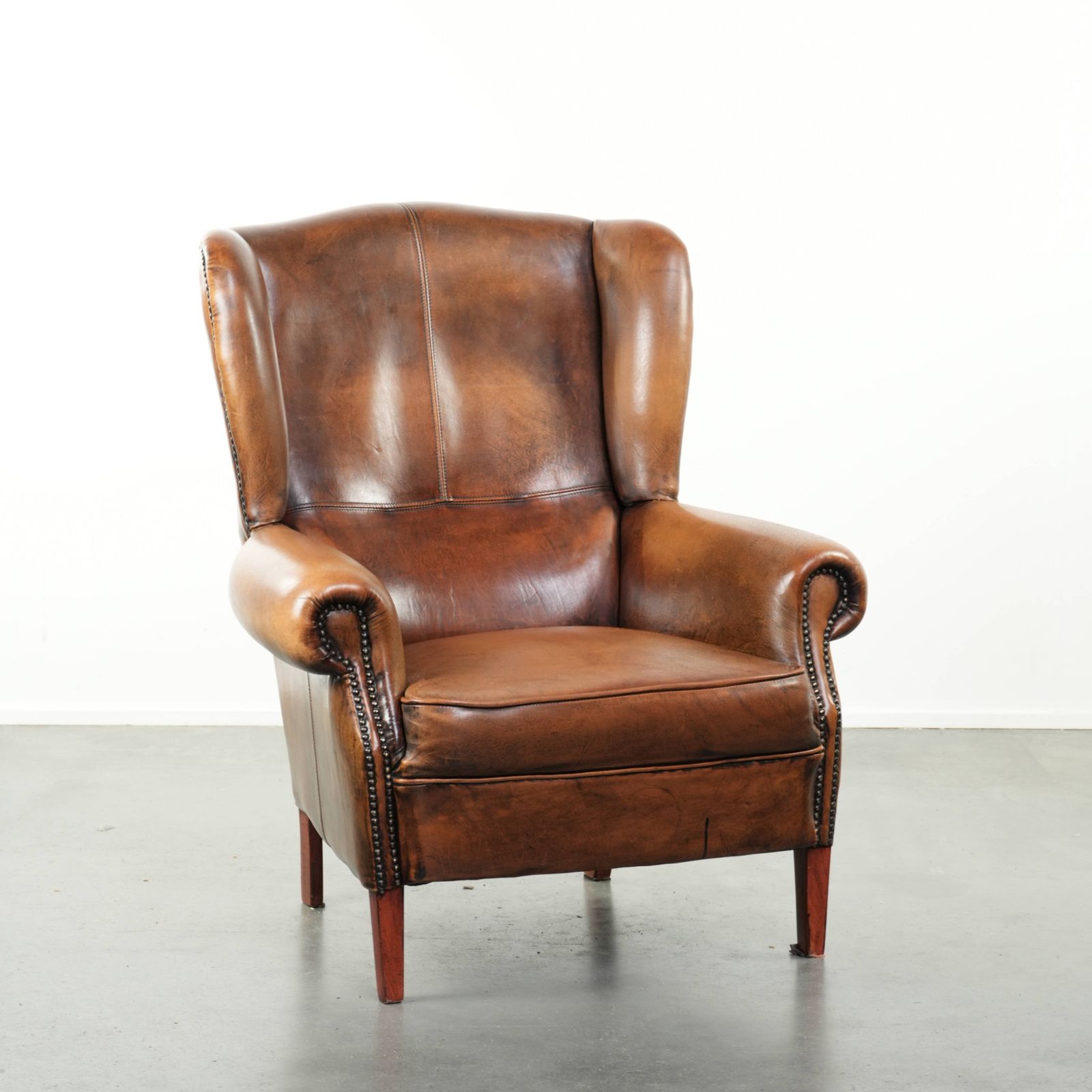 Comfortable Wing Armchair Made Of Sheepskin Finished With Decorative Studs And A Characterful English Style Appearance.