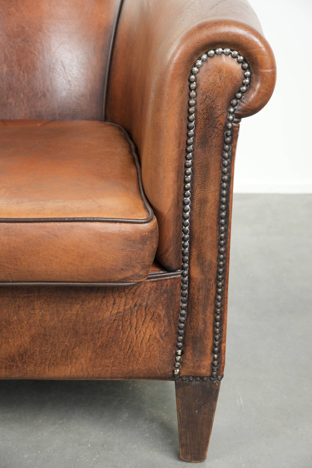 photo furniture Characterful And Comfortable Sheepskin Club Armchair With A Beautiful Patina And A Refined Finish With Black Piping.