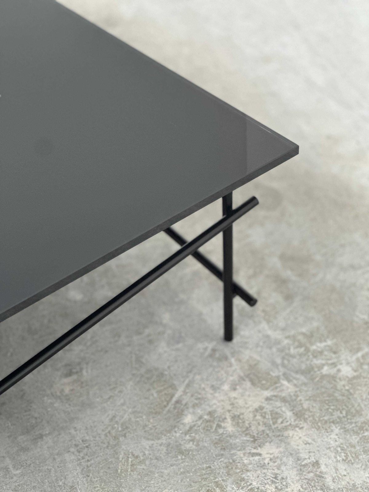 Minimalistische salontafel van zwart glas met industrieel metalen onderstel photo vinterior