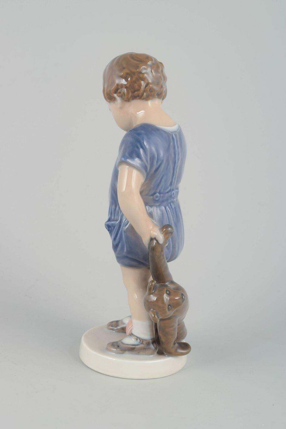 Royal Copenhagen. Porcelain Figurine Of Small Boy With Teddy Bear. photo furniture