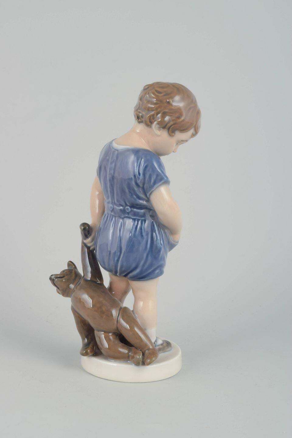 Royal Copenhagen. Figurine en porcelaine de petit garçon avec ours en peluche. photo for sale