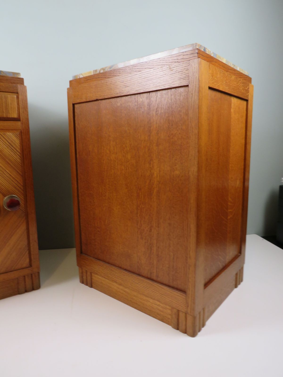 photo furniture Paar Franse art deco nachtkastjes van eiken met ingelegde marmeren bladen
