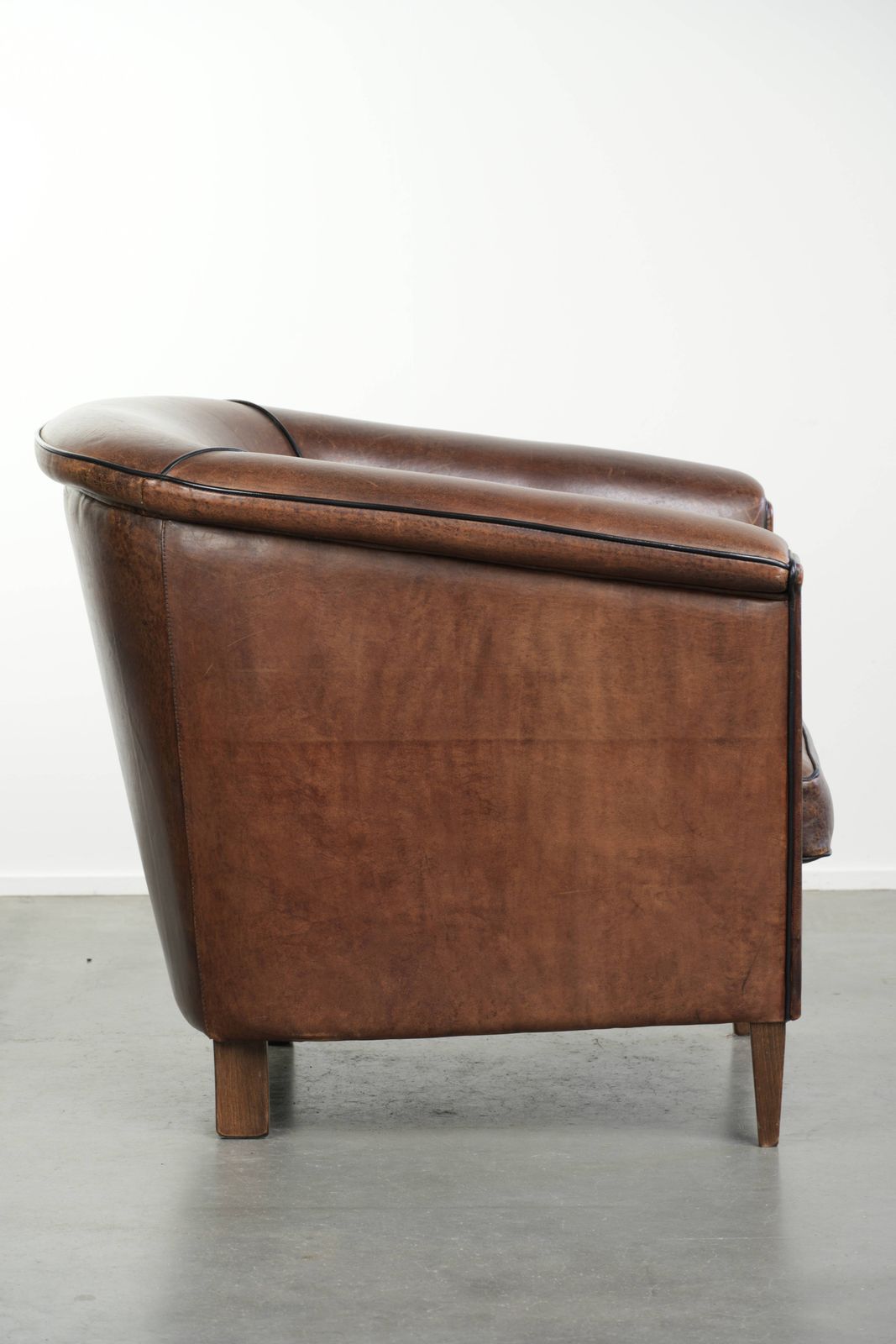 Strakke art deco schapenvacht club fauteuil met zwarte biesafwerking photo for sale