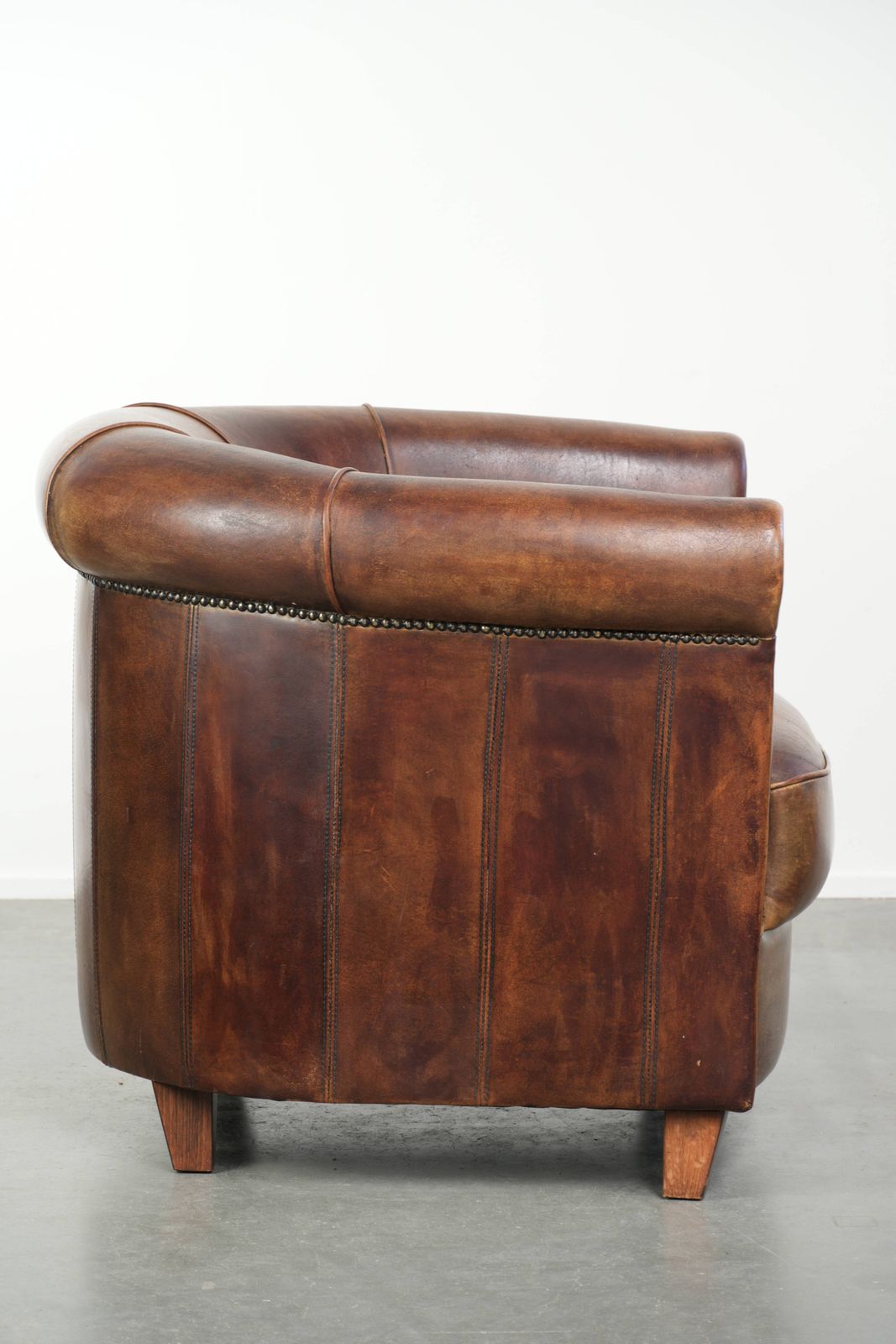 Stevige en karaktervolle clubfauteuil in schapenleer met een mooie patina, afgewerkt met decoratieve nagels. photo for sale