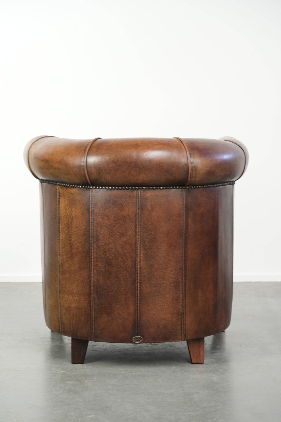 Stevige en karaktervolle clubfauteuil in schapenleer met een mooie patina, afgewerkt met decoratieve nagels. photo Meubels
