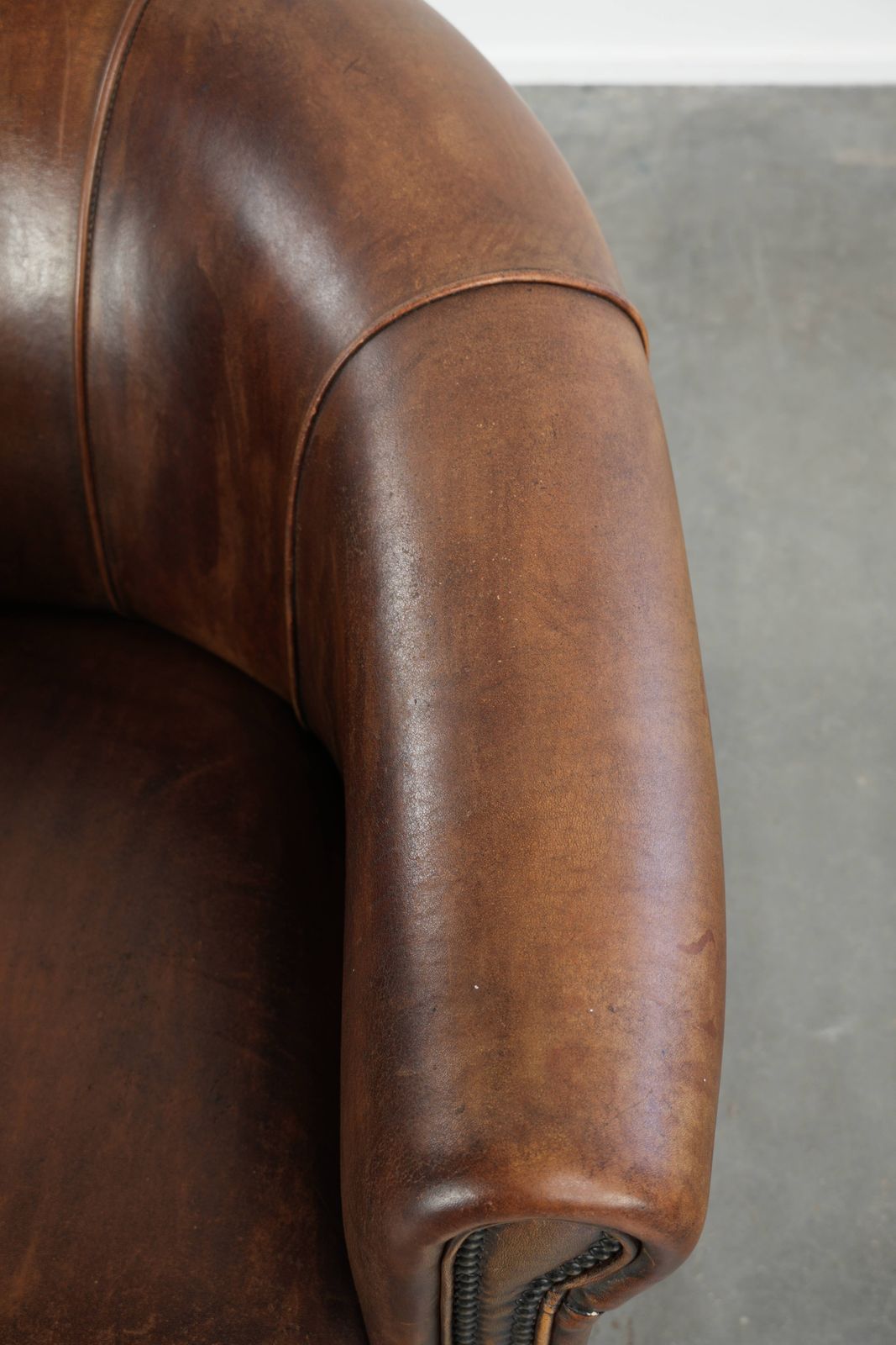 Stevige en karaktervolle clubfauteuil in schapenleer met een mooie patina, afgewerkt met decoratieve nagels. photo vintage