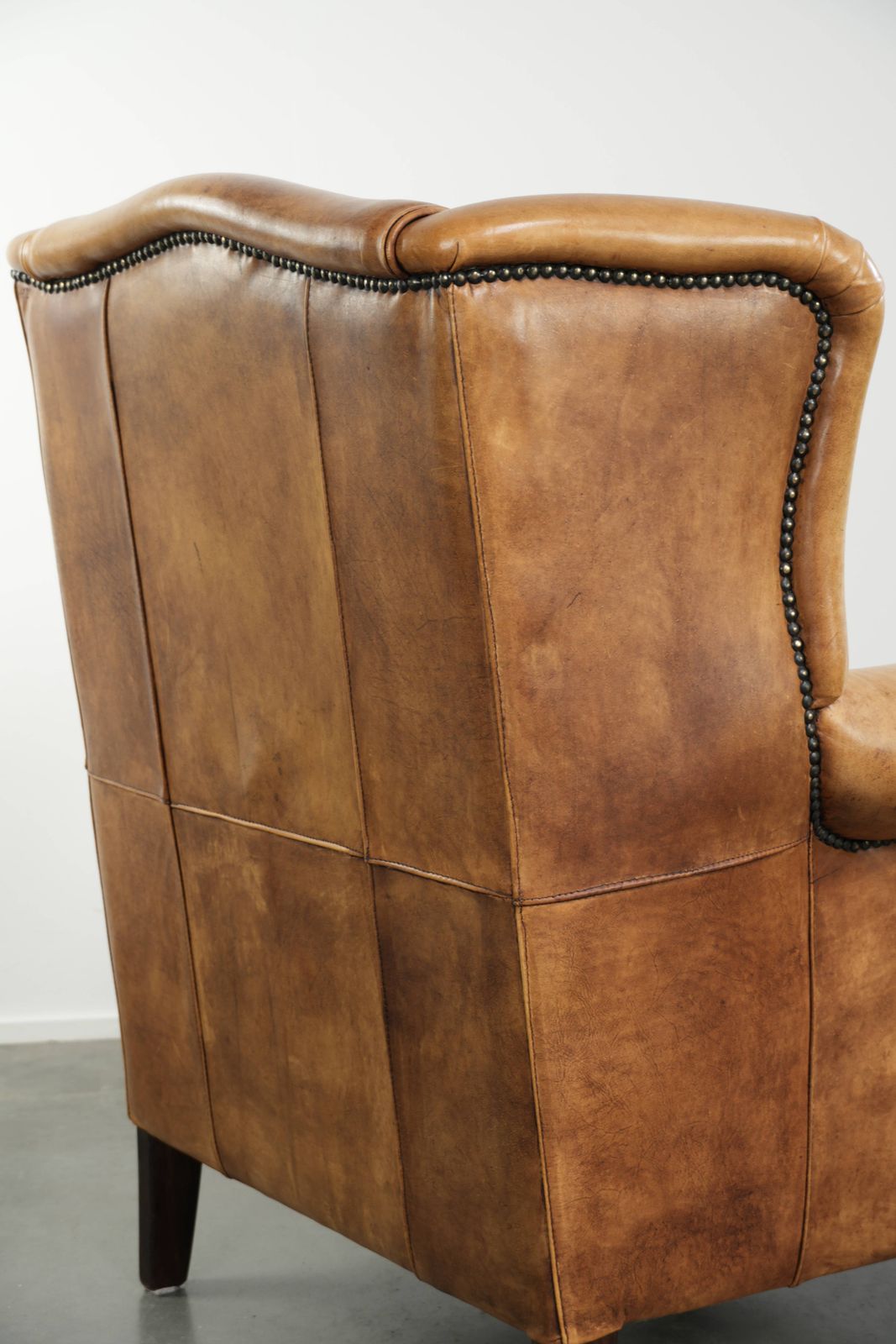 931.0 Lichte koeienhuid fauteuil met vleugelleuningen, een mooie tijdloze Engelse uitstraling en goed zitcomfort. photo