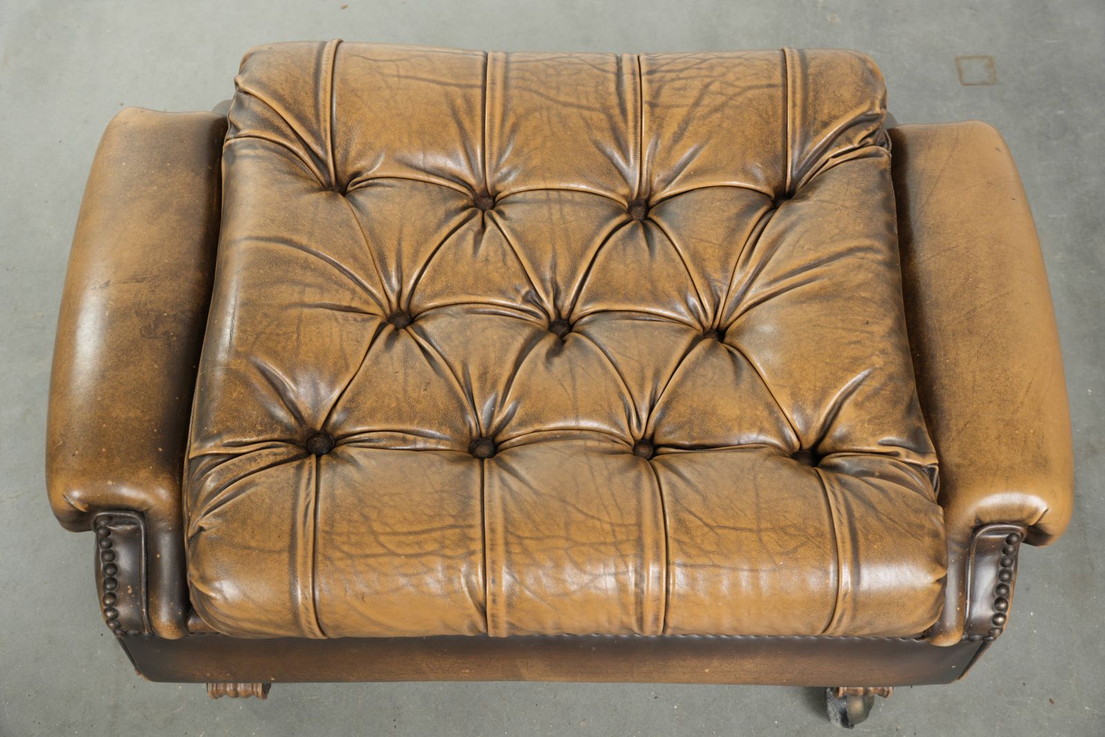 Unieke en elegante Engelse Chesterfield ottoman in koeienhuidleer op wieltjes, afgewerkt met decoratieve nagels. photo vinterior
