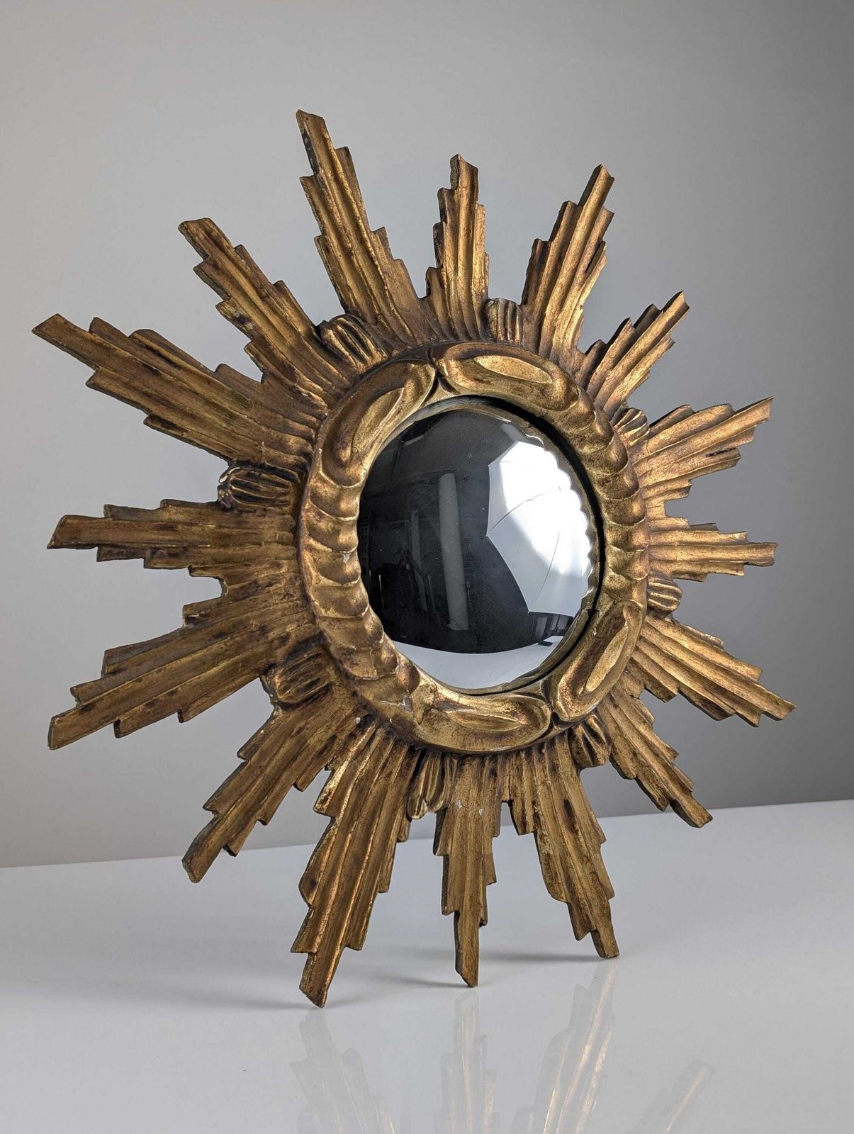 Miroir mural convexe en bois doré sculpté à décor de soleil, années 1950