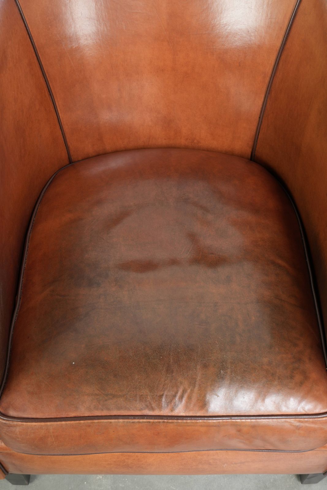 Vintage Schapenvacht Club Fauteuil Met Warm Kleurenschema En Afgewerkt Met Zwarte Paspel. photo vinterior