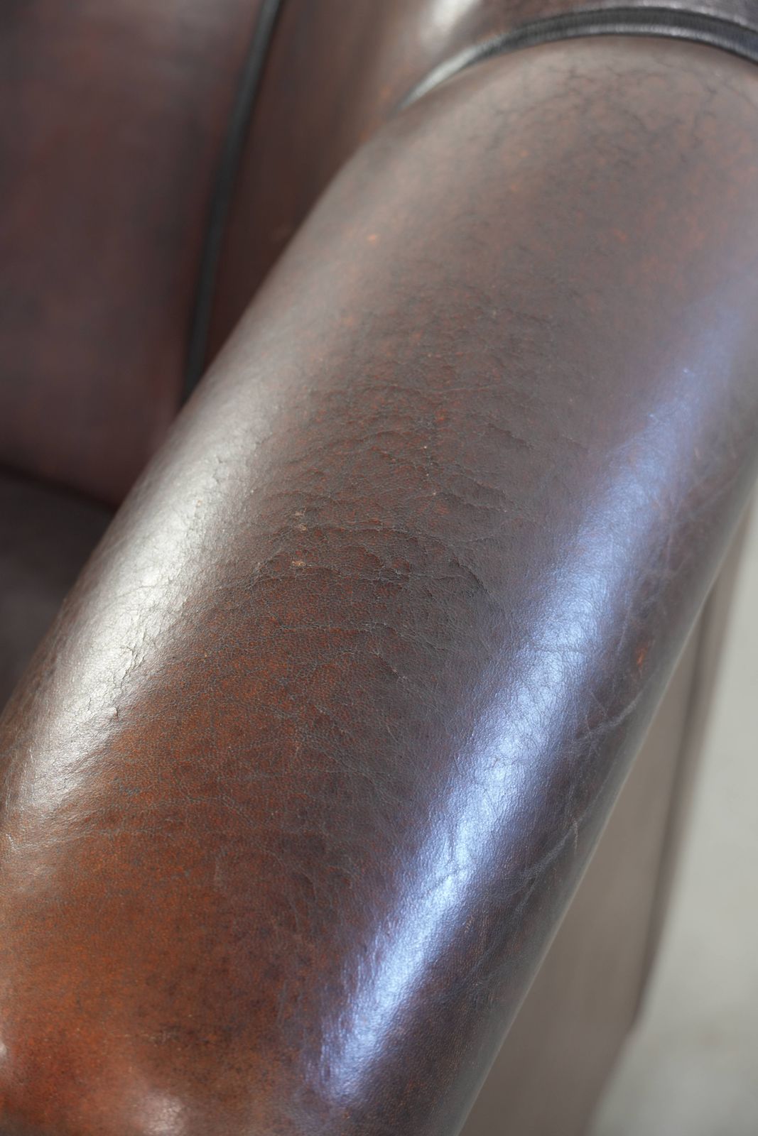 936.0 Donkere schapenleren club fauteuil met uniek ontwerp en aantrekkelijke patina in Engelse stijl. photo