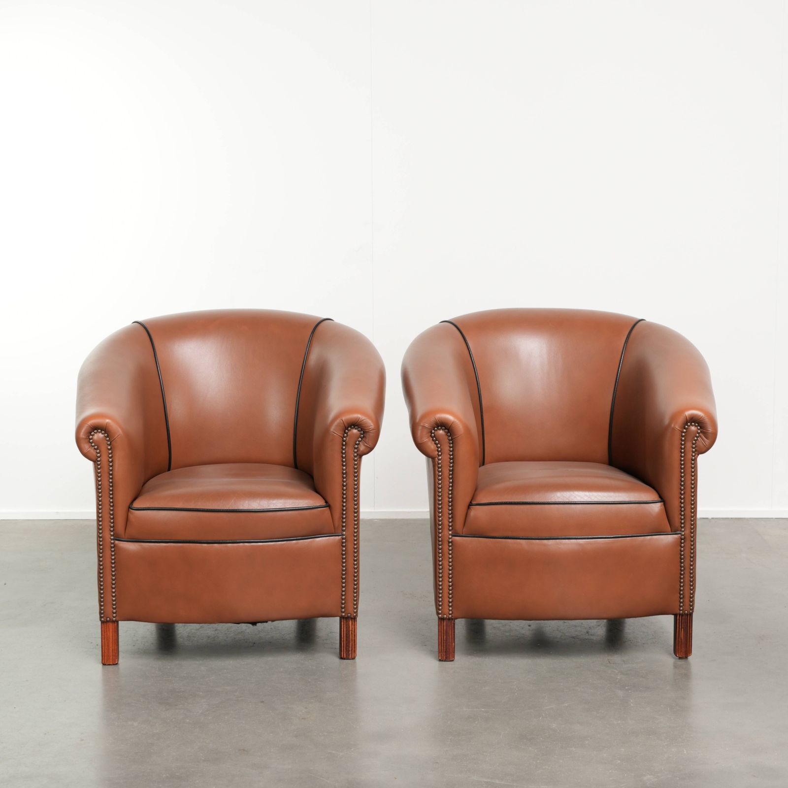 Set van 2 koehuidenleren club fauteuils in goede staat met een luxueuze Engelse uitstraling.