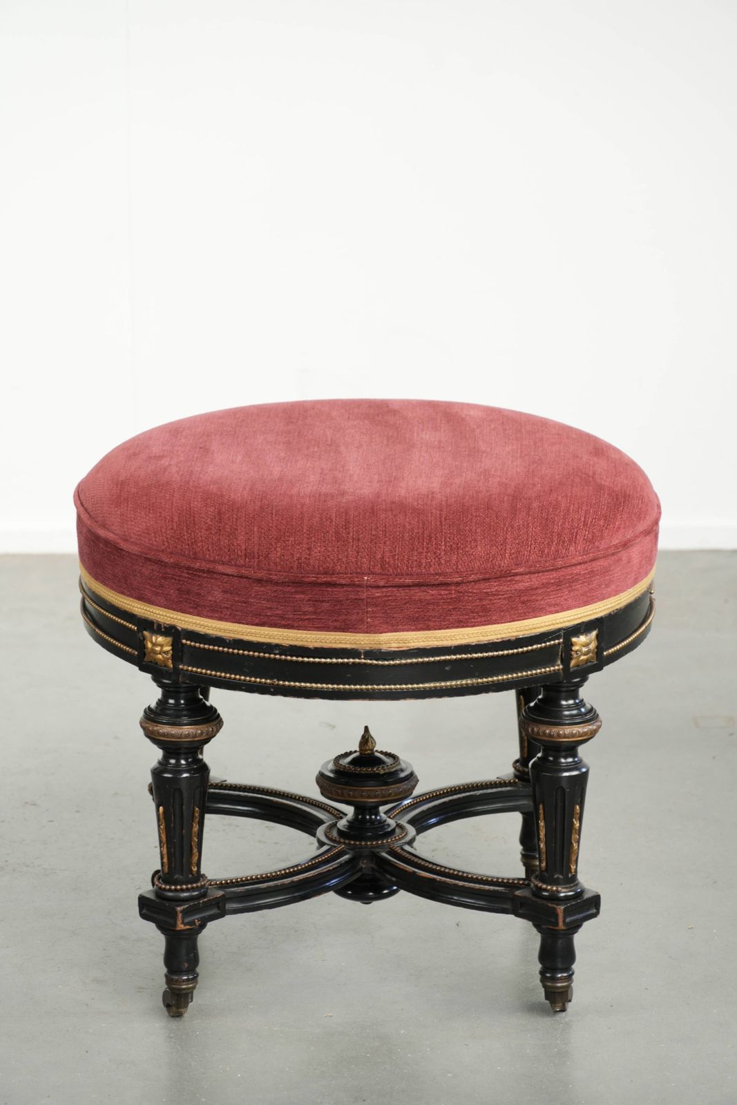 Antieke Engelse kruk met rode stoffen zitting en zwart houten onderstel met goudkleurige details photo for sale