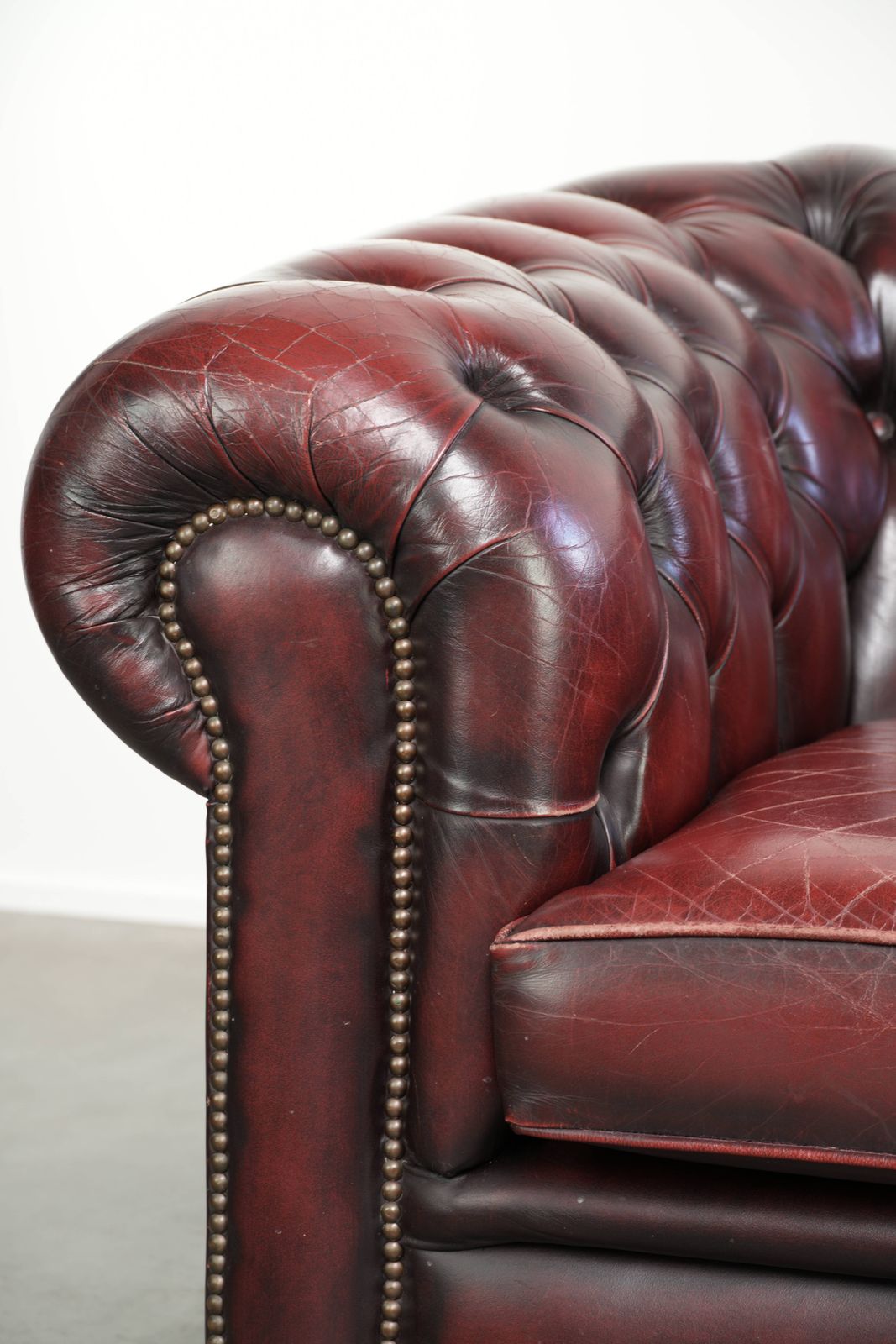 photo for sale Chique Engelse Chesterfield Club Fauteuil met Gebruikssporen in een Tijdloze Rode Kleur