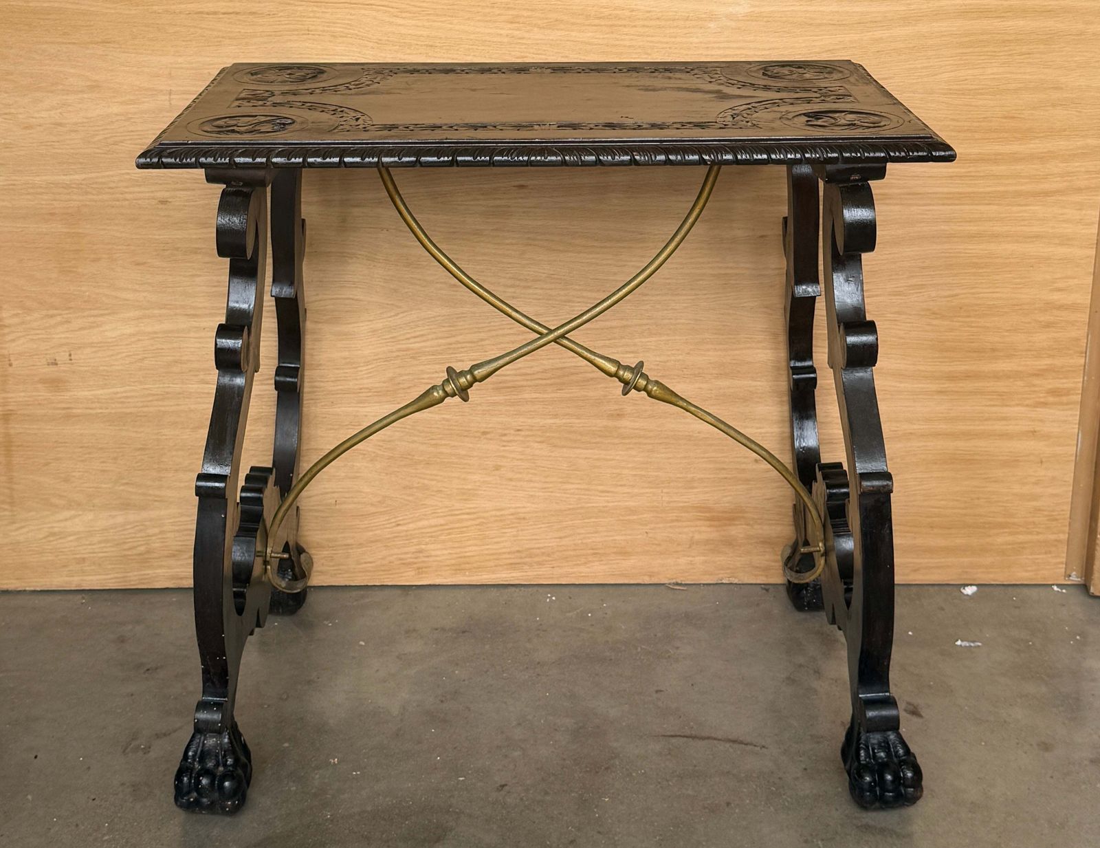 Table centrale d'époque en bois ébénisé sculpté, traverses en laiton et pieds en patte photo for sale