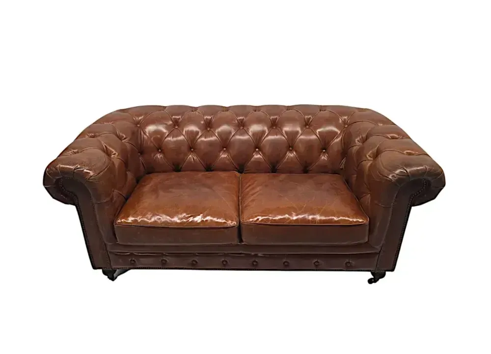 Een fraaie leren chesterfield tweezitsbank in de Victoriaanse stijl. photo Meubels