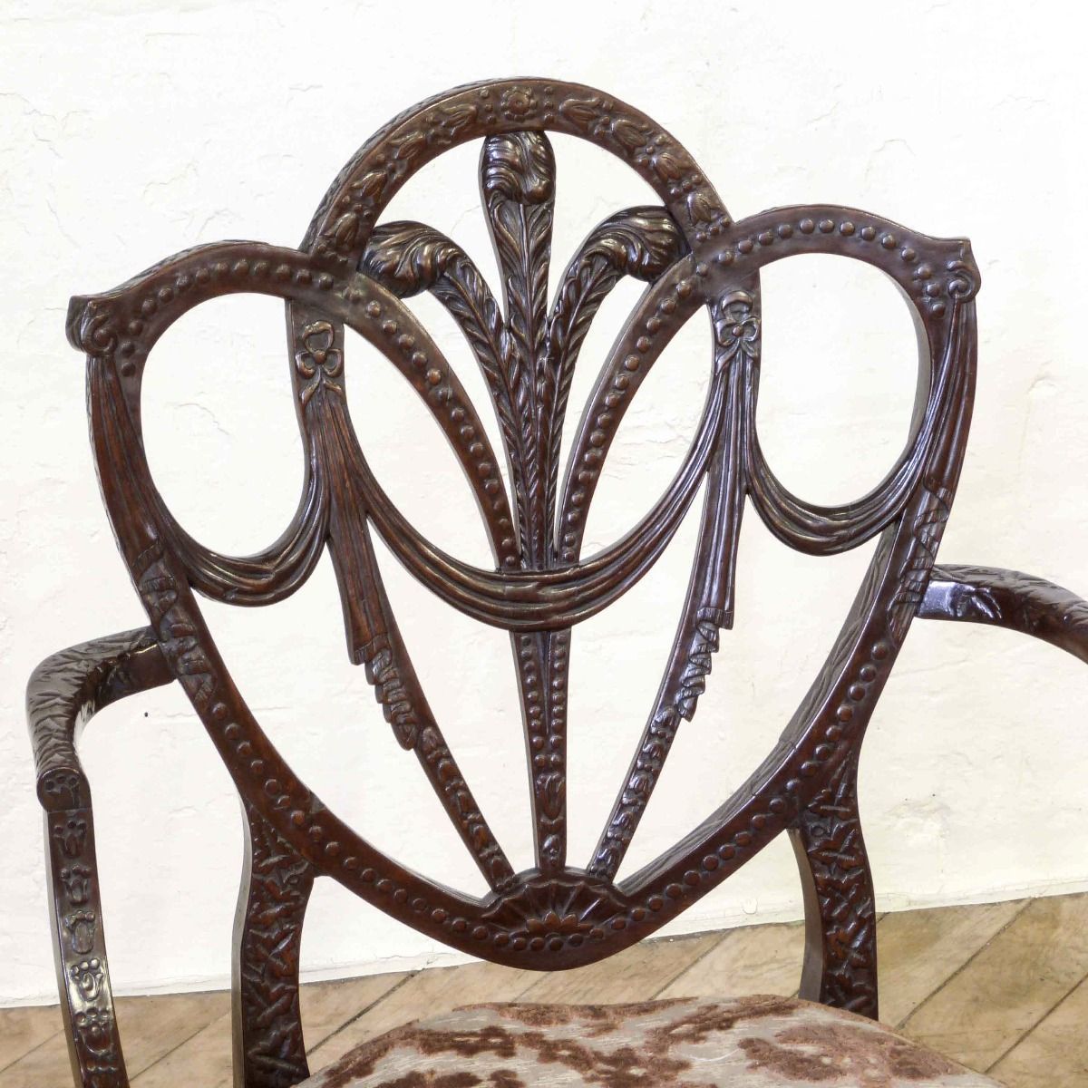 A Pair Of Edwardian Mahogany Armchairs In The Manner Of Hepplewhite. Profusely Carved With Foliage, Flowers, Ribbons And Swags. The Central Shield Bac photo 2220.0