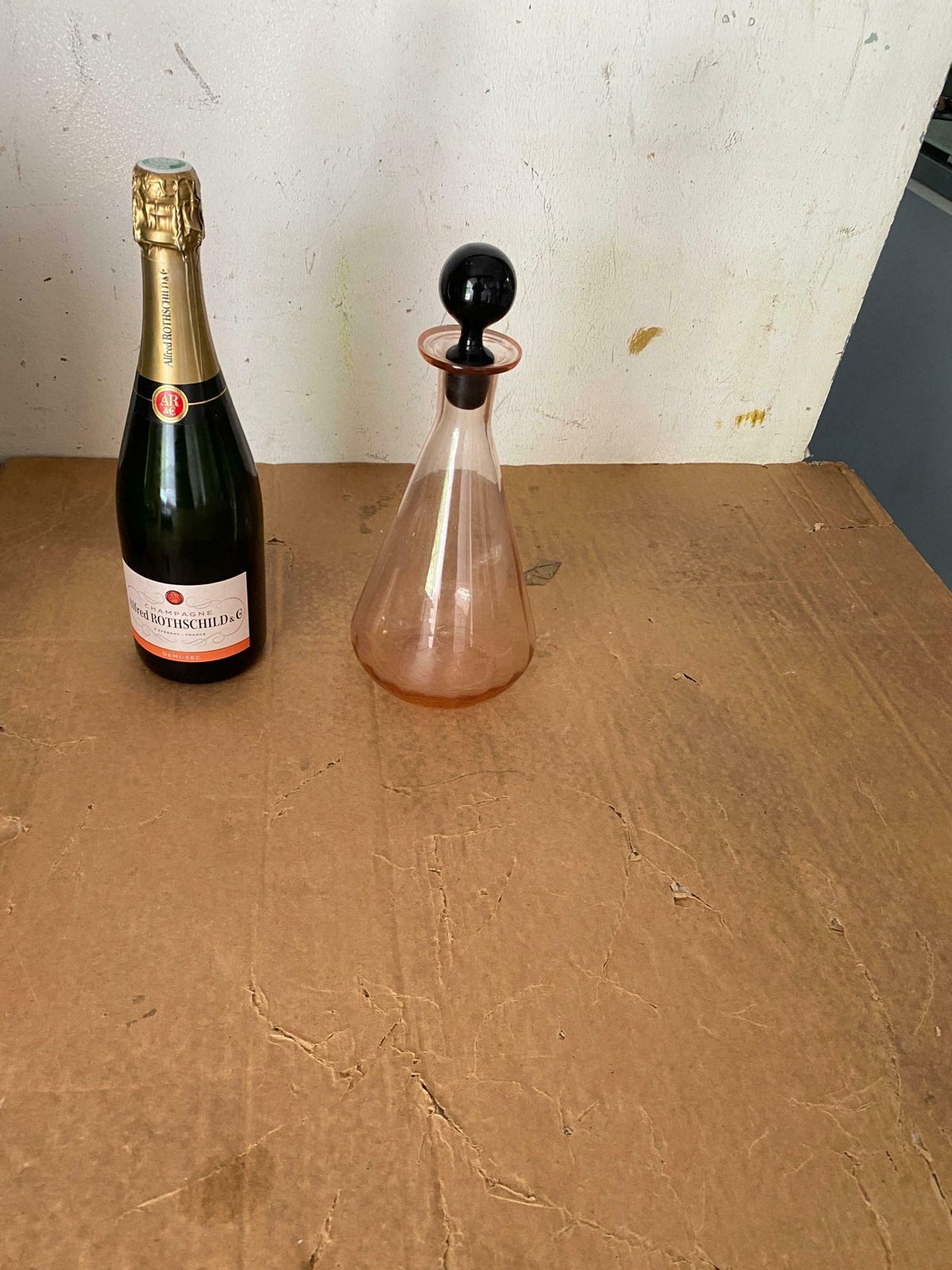 photo for sale Decorative Vintage Pink Glass Bottle In Glass With Black Cap, France, Circa 1940